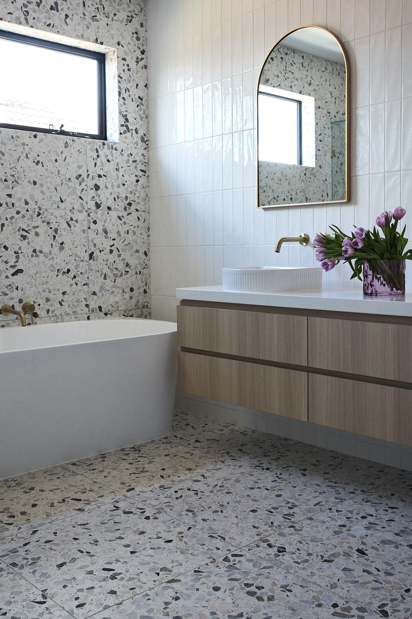 Large format terrazzo tile with feautre subway tile in a fun, playful bathroom in a Thomas Archer home