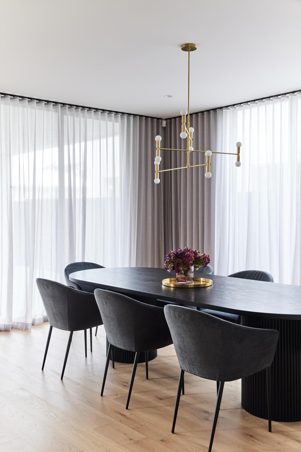 Contemporary Feature Lighting Over Black Dining Room Table And Chairs