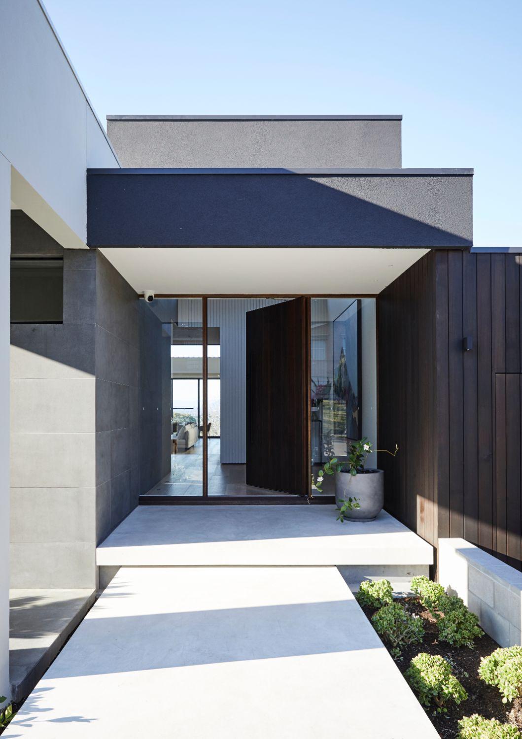 Concrete Slab Pathway Leads To Timber Pivot Door Entry