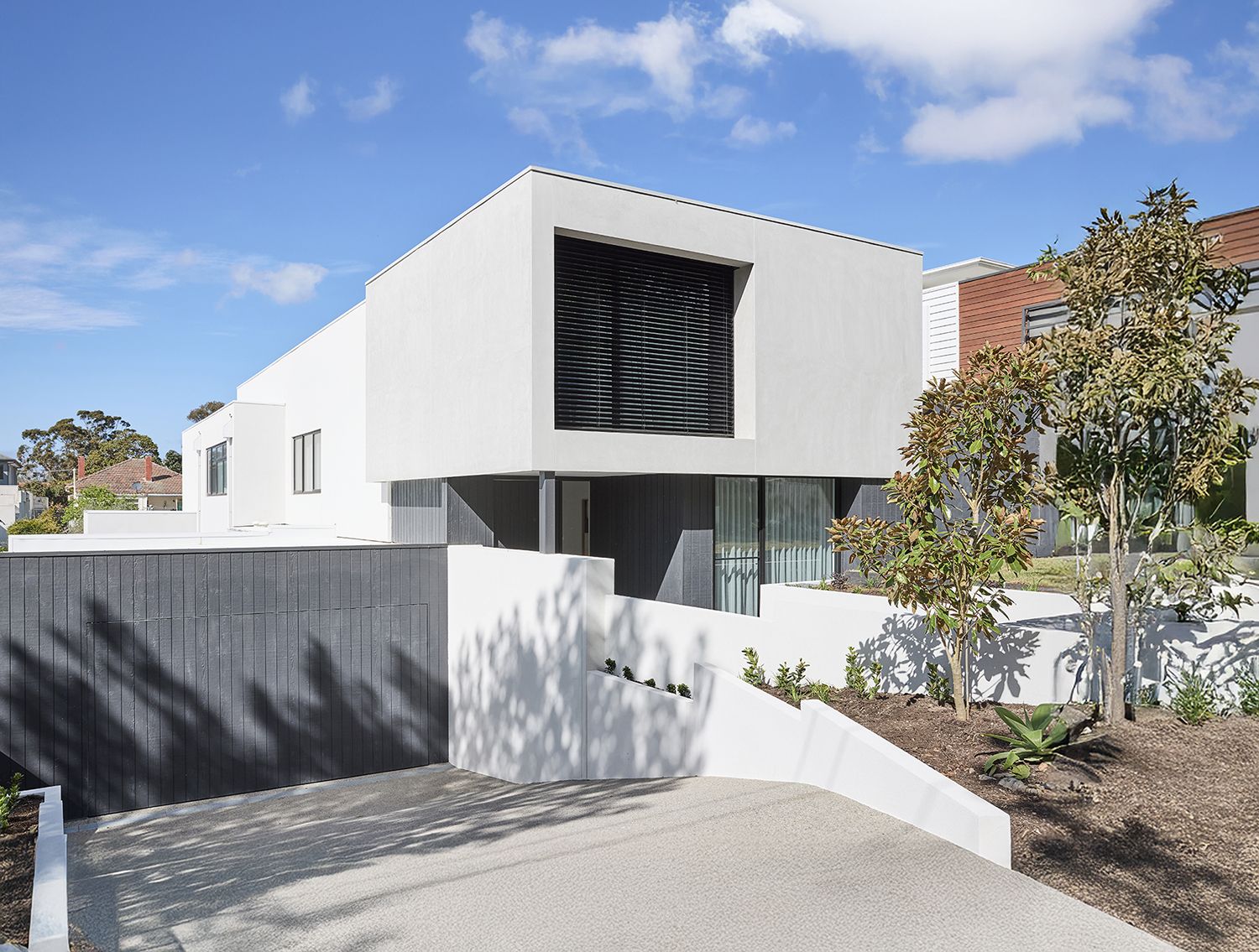 A custom, architecturally designed facade by Thomas Archer with landscaping in the foreground