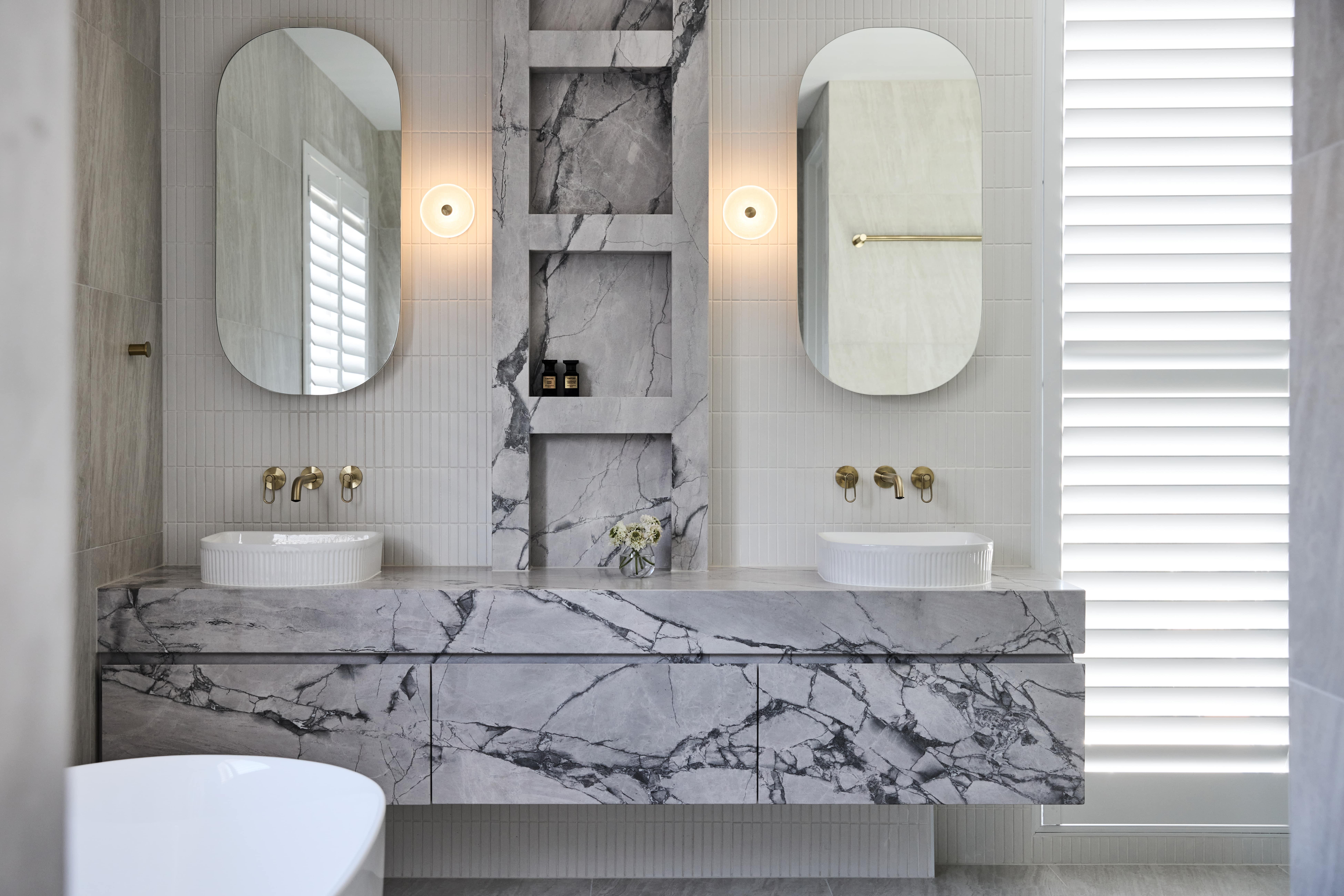 Beautifully designed master ensuite featuring a striking Super White stone vanity and benchtop, creating a bold statement in this Thomas Archer-designed and built home.