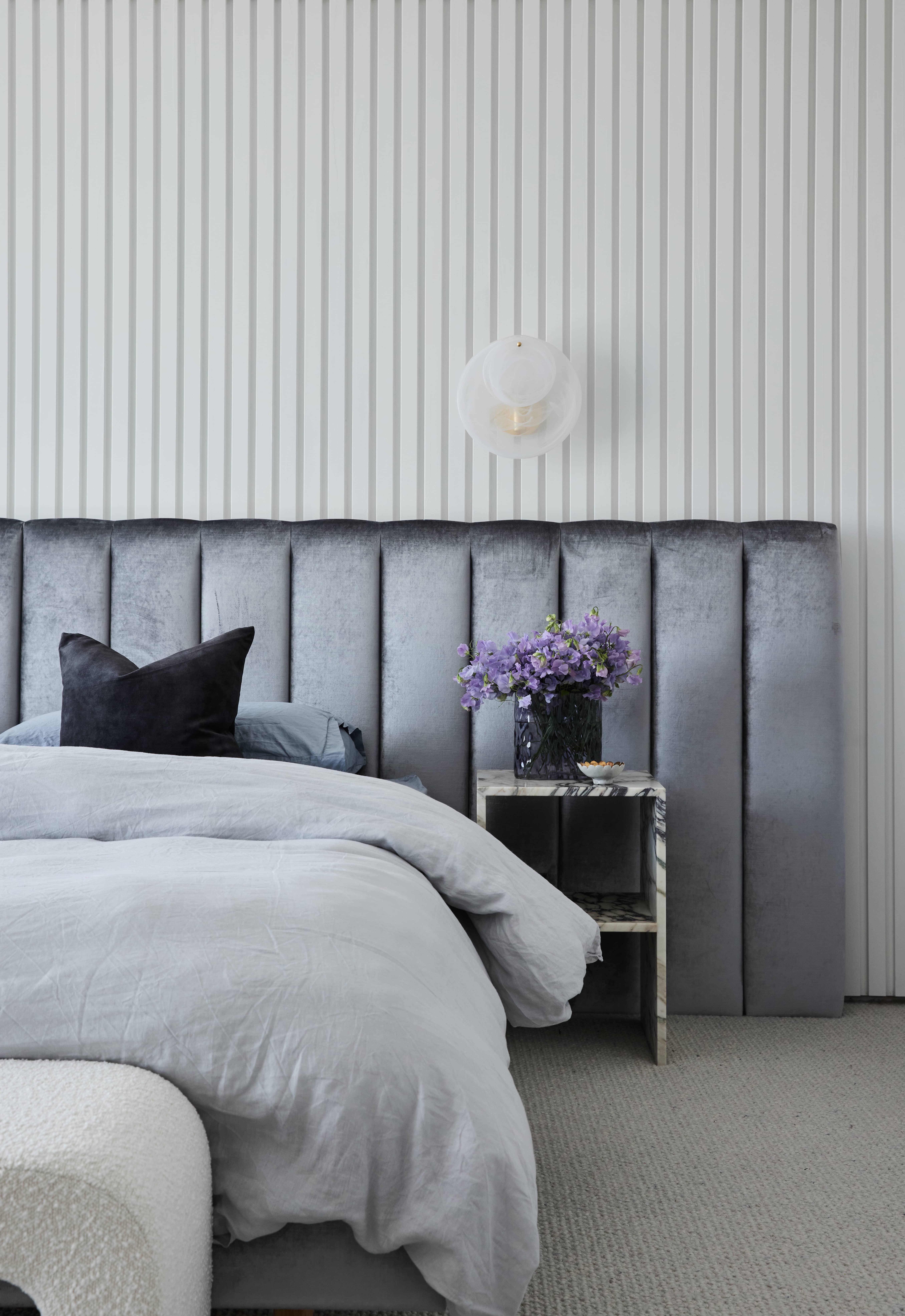 Master bedroom at the Strathmore Residence featuring floor-to-ceiling wall cladding and soft tones that create a relaxing retreat.