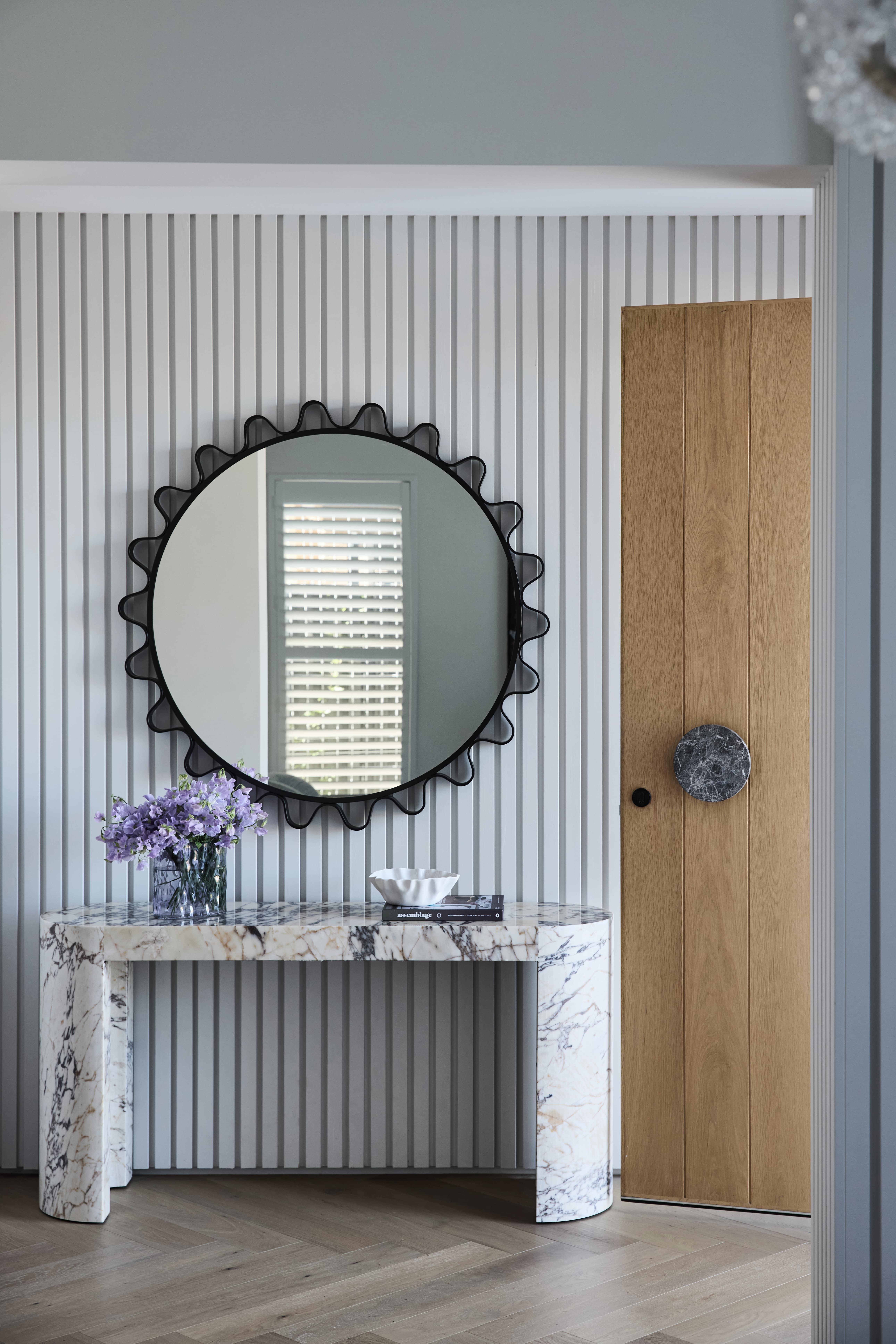 Striking entryway with herringbone flooring and floor-to-ceiling cladding, designed and built by Thomas Archer.