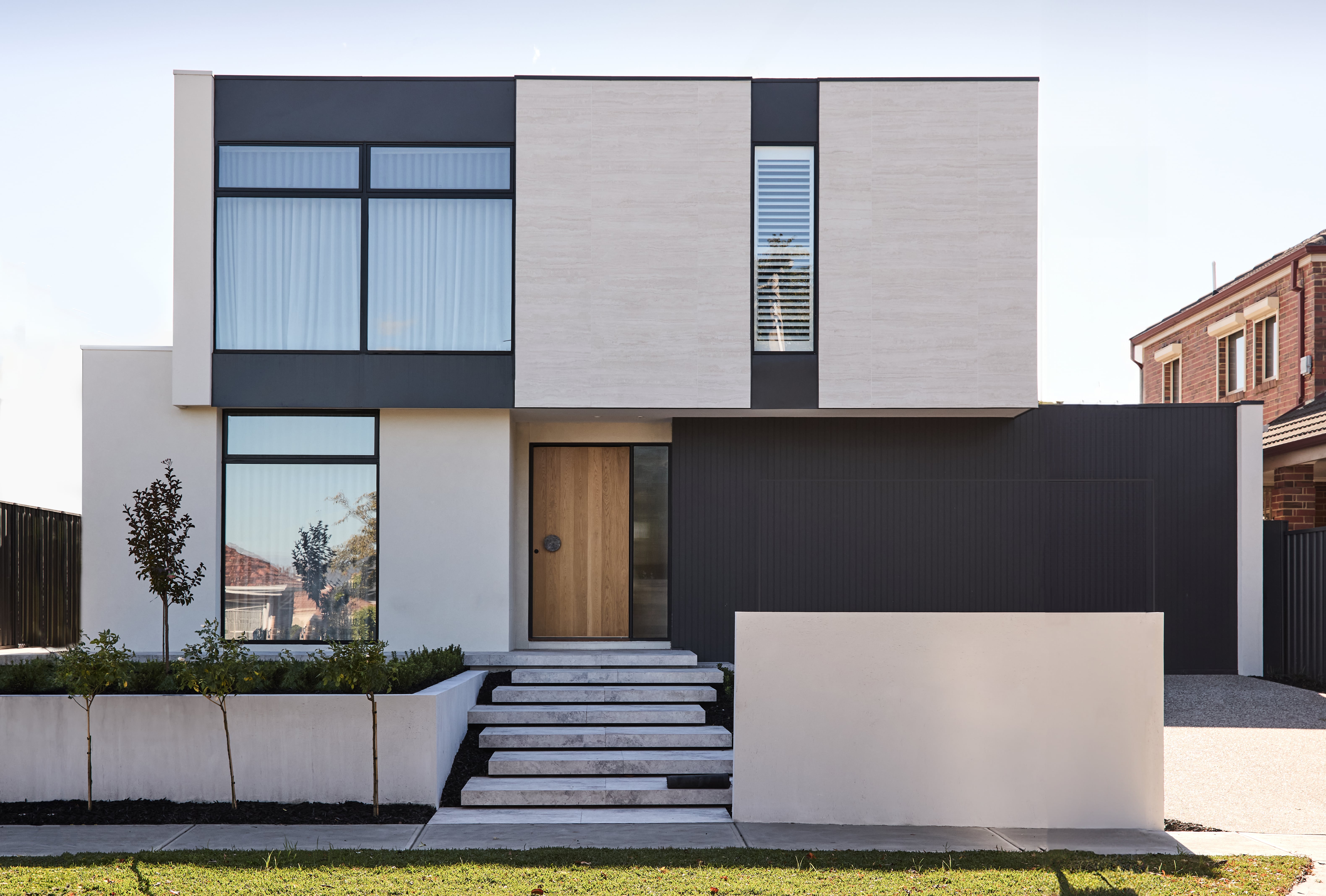 A contemporary, architecturally designed facade by Thomas Archer with landscaping in the foreground