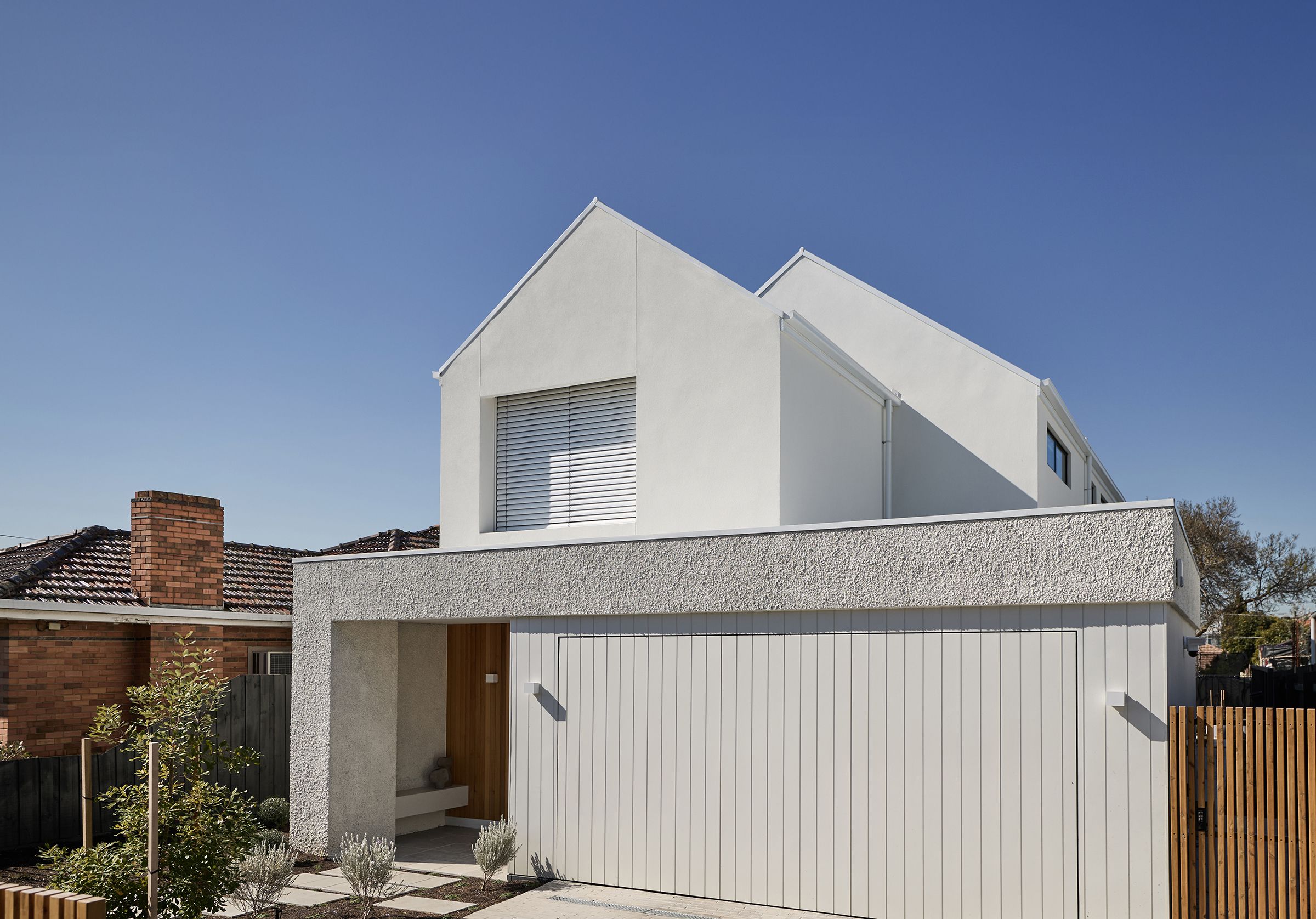 A custom, architecturally designed facade by Thomas Archer with landscaping in the foreground