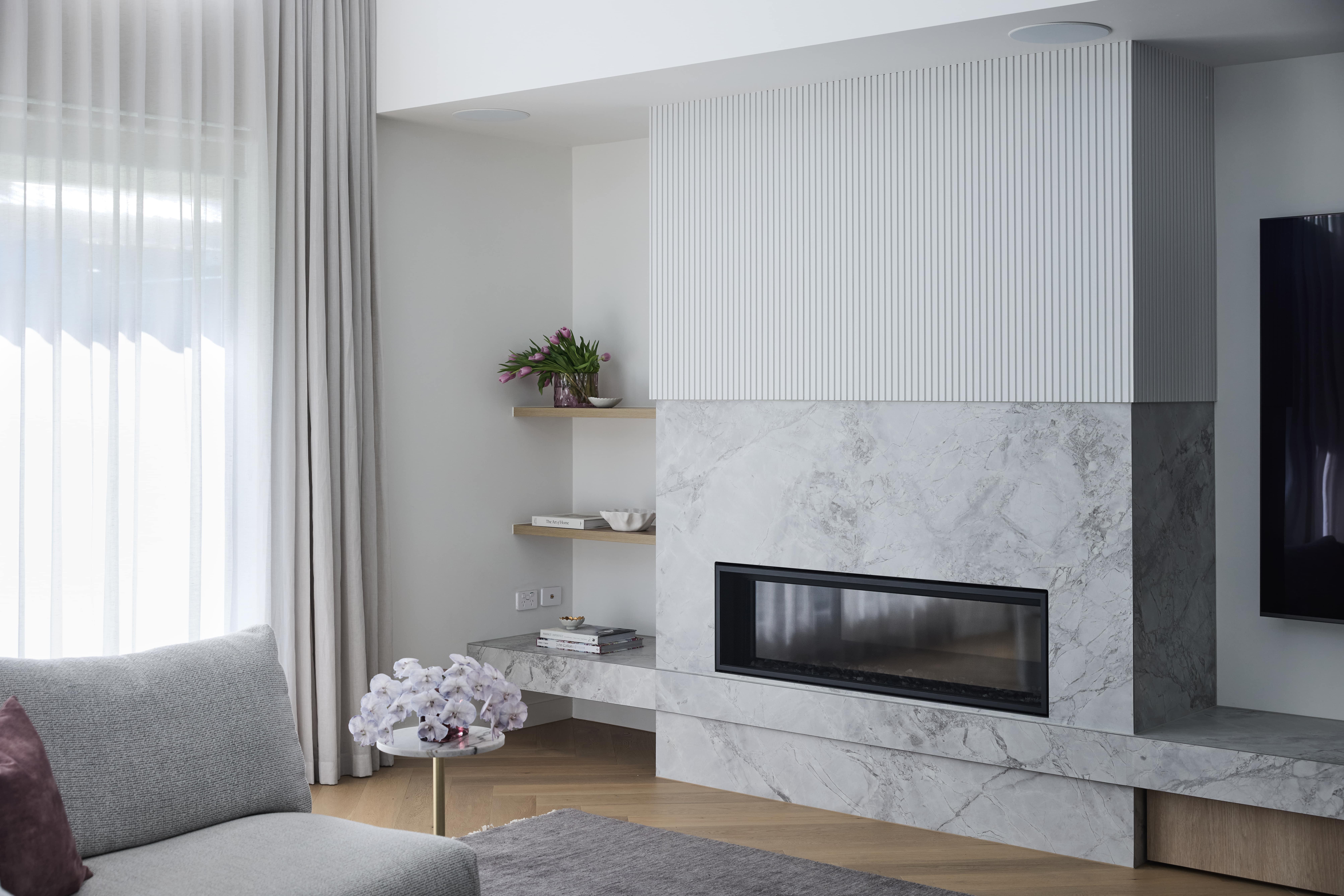 Feature fireplace with Super White stone cladding in the Strathmore residence by Thomas Archer