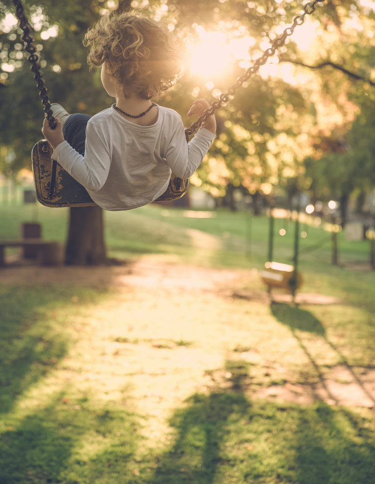 child on swing in park