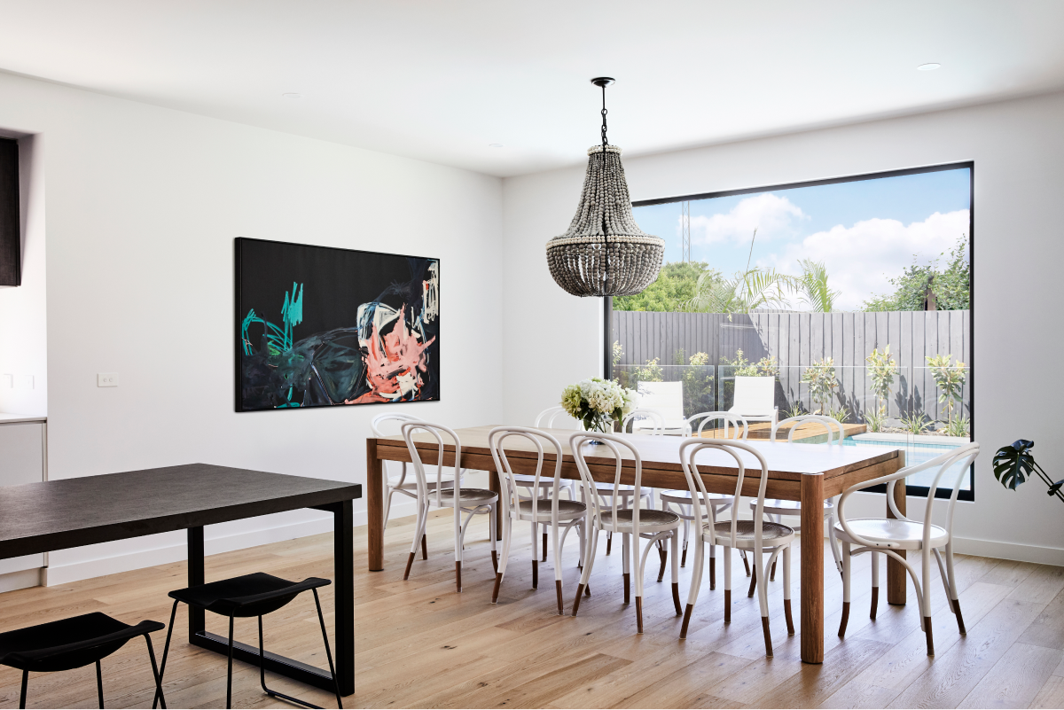 Dining room with large painting on wall and beaded chandelier