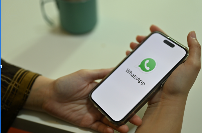 A person opening up WhatsApp on their phone.