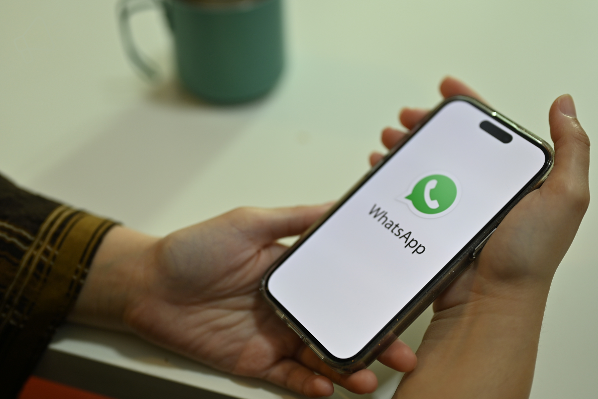 Iemand die WhatsApp op zijn telefoon opent.