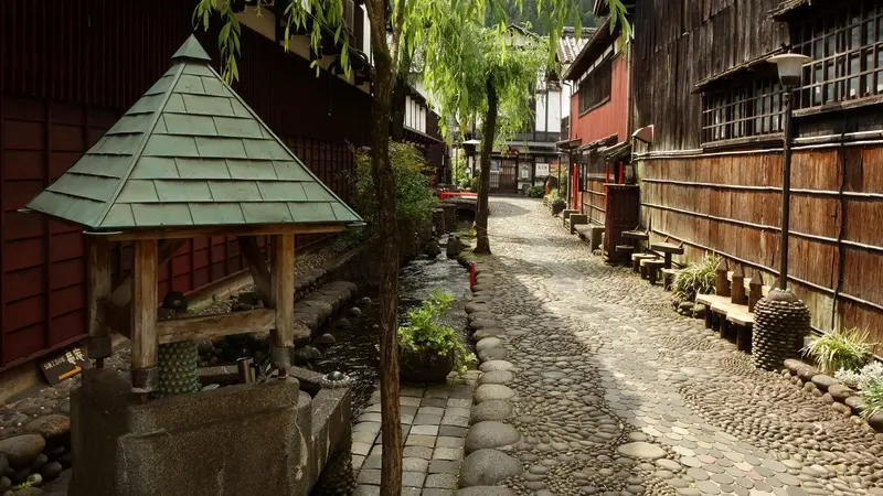 Yanaka Mizu no Komichi, a stone-paved lane lined with traditional wooden buildings in Gujo Hachiman, Gifu Prefecture, Japan.