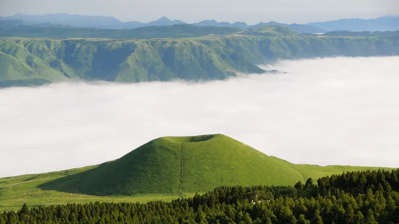 Komezuka's green volcanic cone above a sea of clouds in Aso, Kumamoto, Japan.
