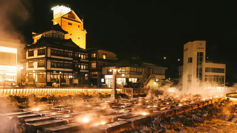 Steam rising from the illuminated Yubatake hot spring field at night in Kusatsu Onsen, Gunma