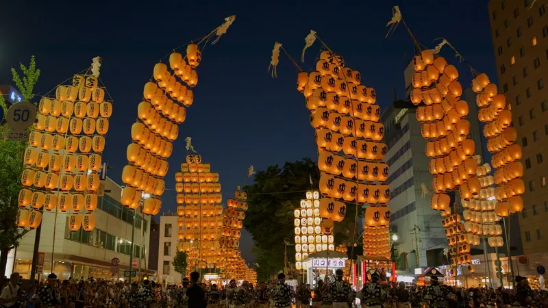 Illuminated lantern poles at the Akita Kanto Festival at night