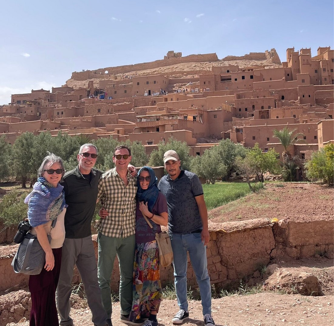 Four guests with their AZA Morocco Tours guide in front of the Aït Benhaddou kasbah