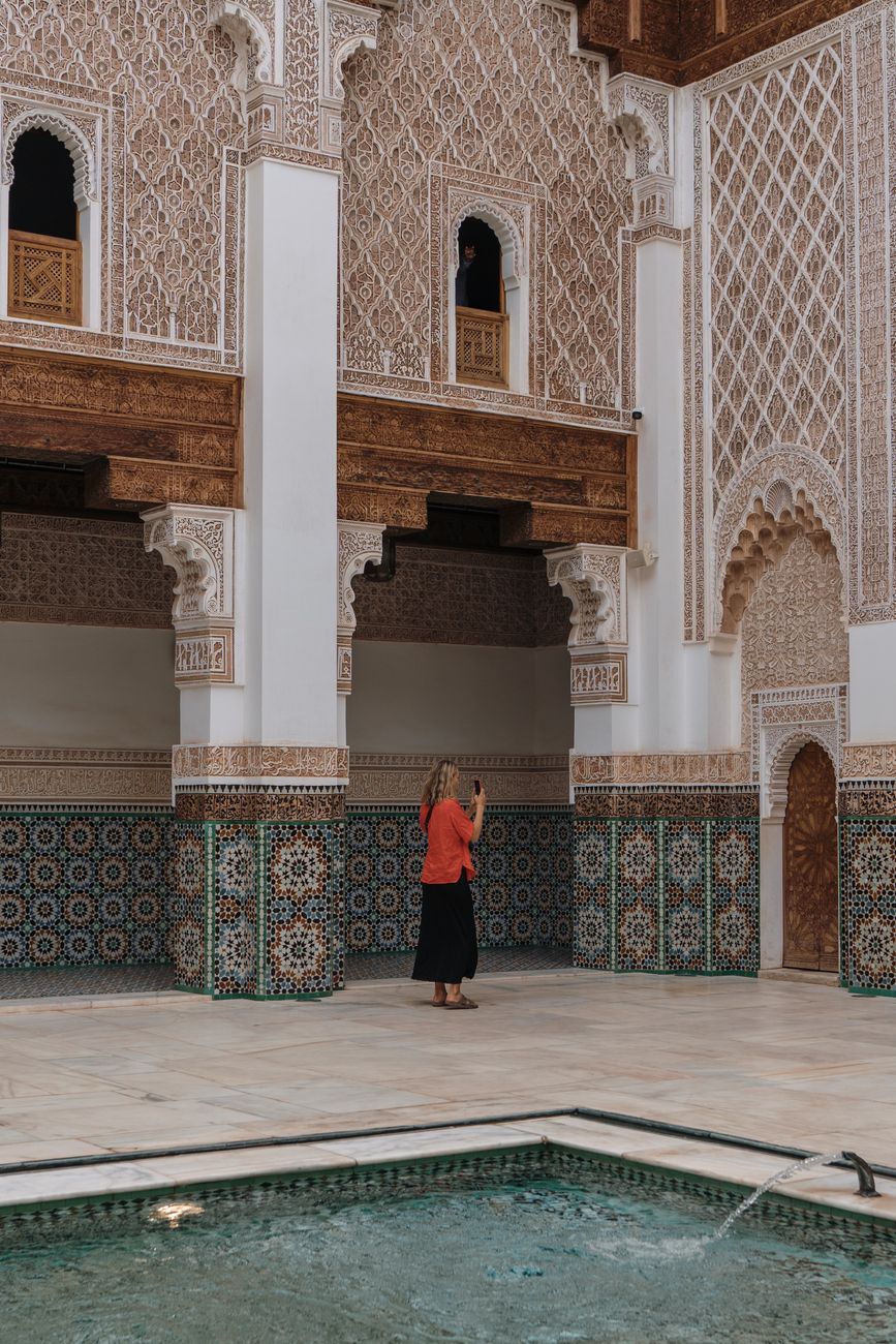 Captivating view of ornate Moroccan architecture with a tourist photographing in Marrakesh.