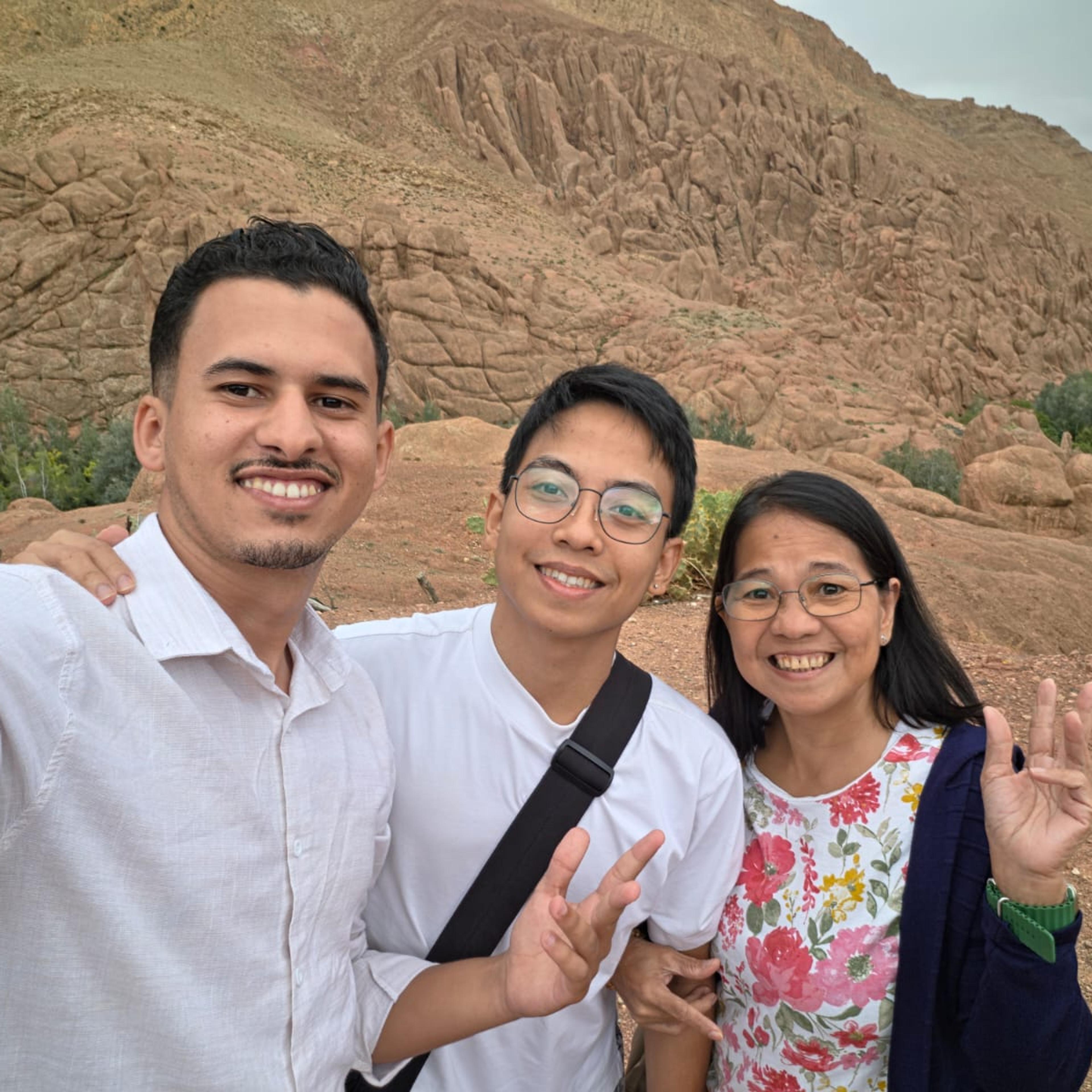 Moha from AZA Morocco Tours with two guests in front of the Monkey Fingers rock formations, Dades Valley