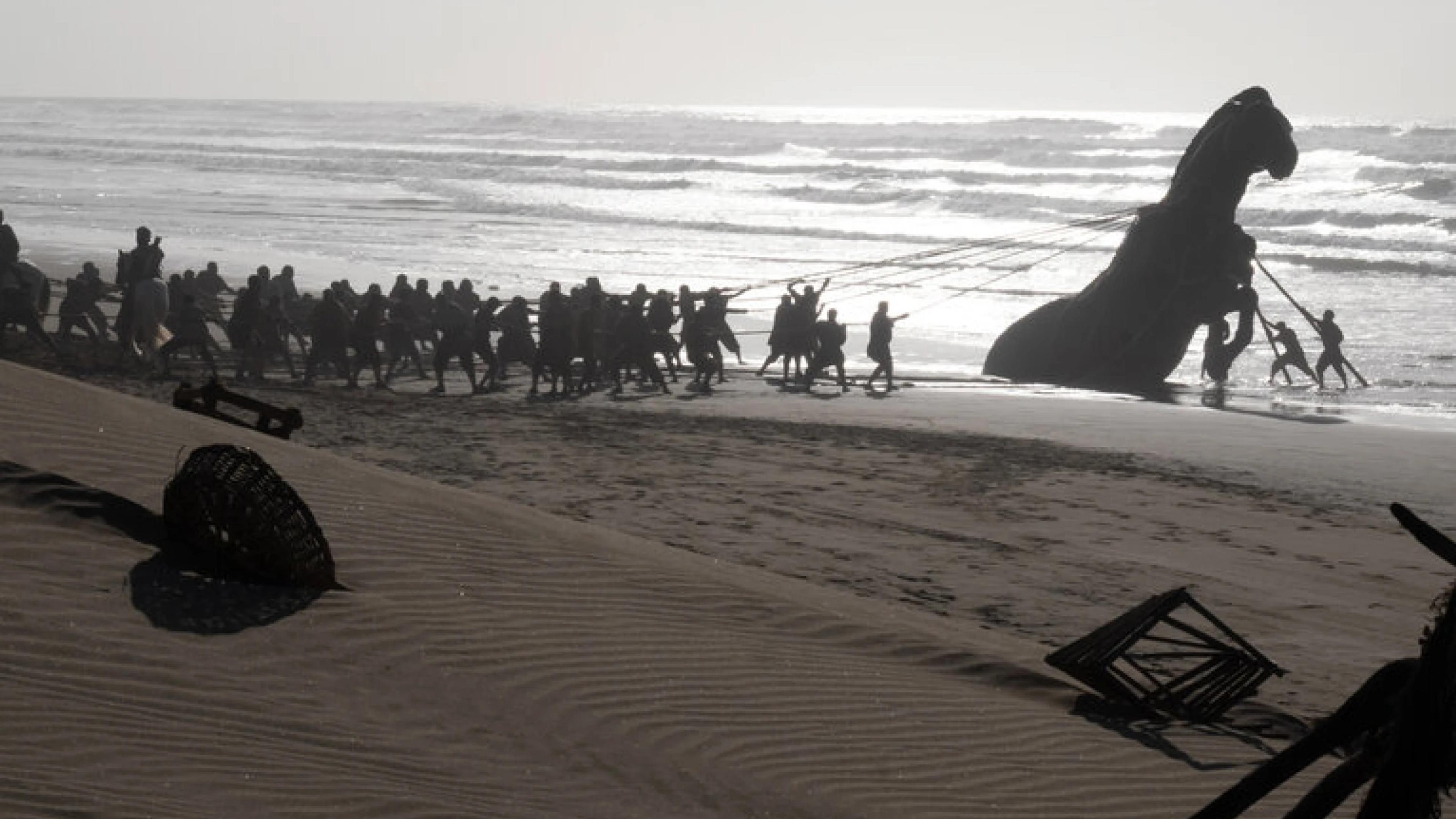 Behind-the-scenes photo of the Trojan Horse being pulled onto a Moroccan beach during filming of The Odyssey