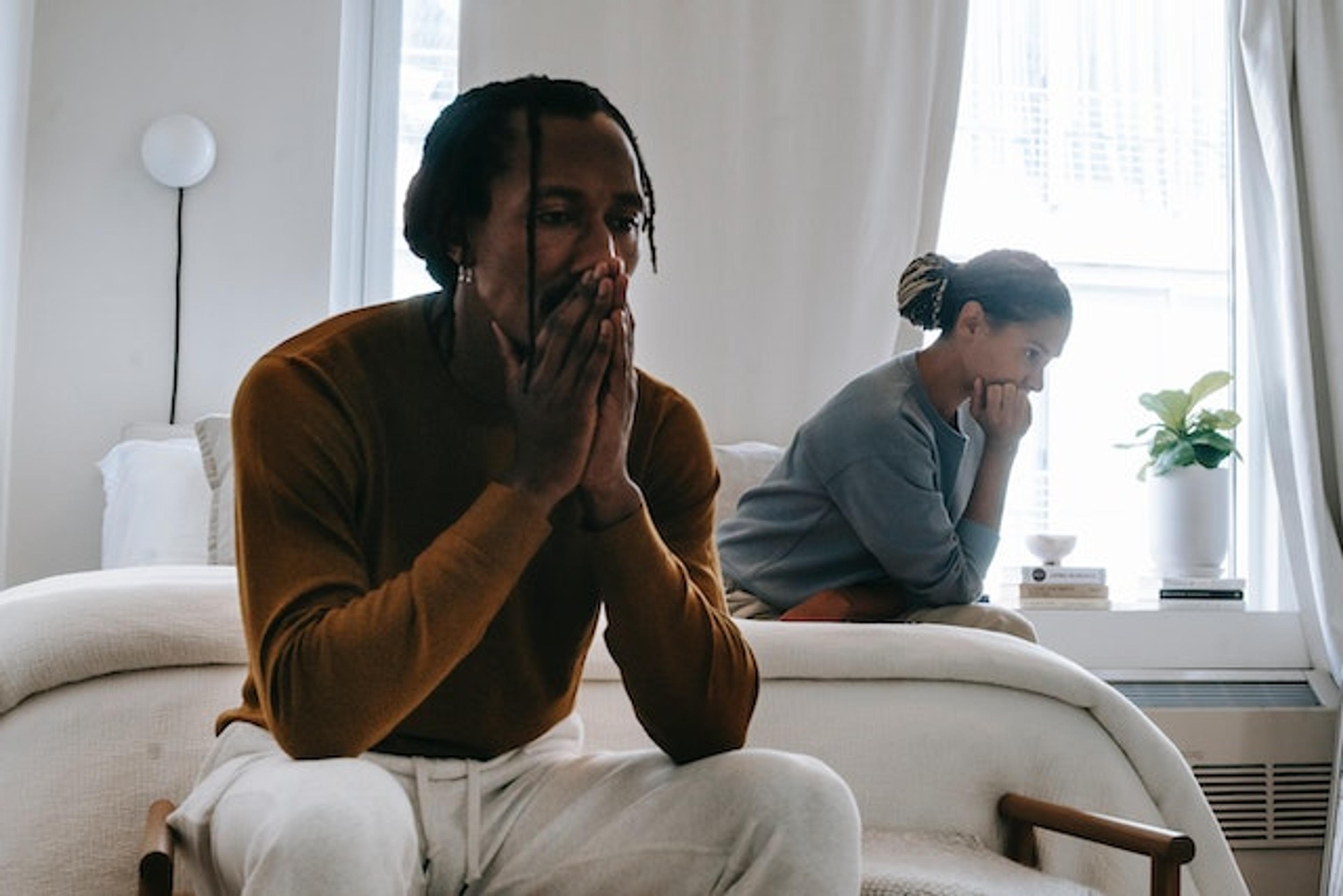 A couple sitting in the couch experiences some common relationship problems