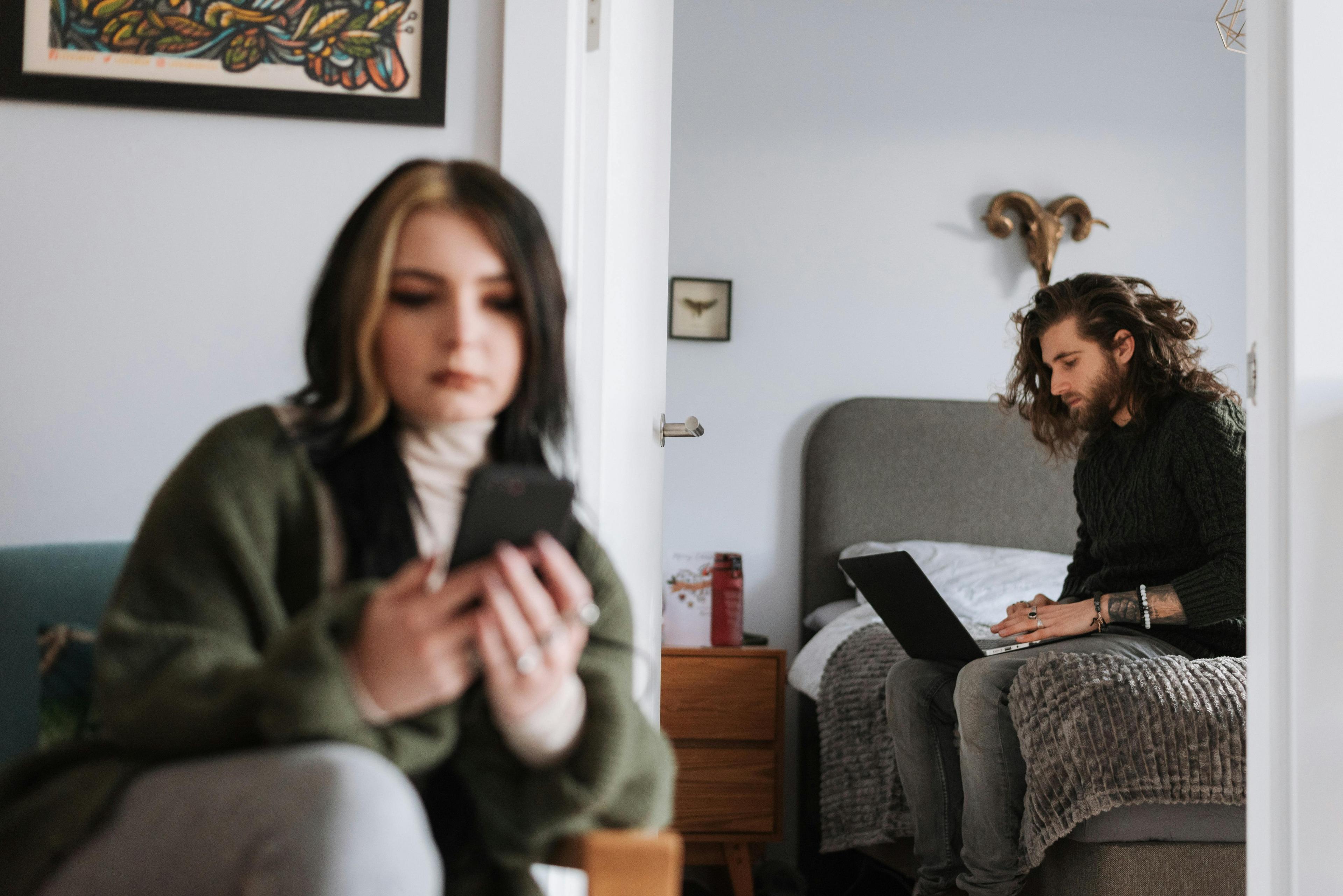 A woman and a man sitting in their home navigating trough their work-life balance