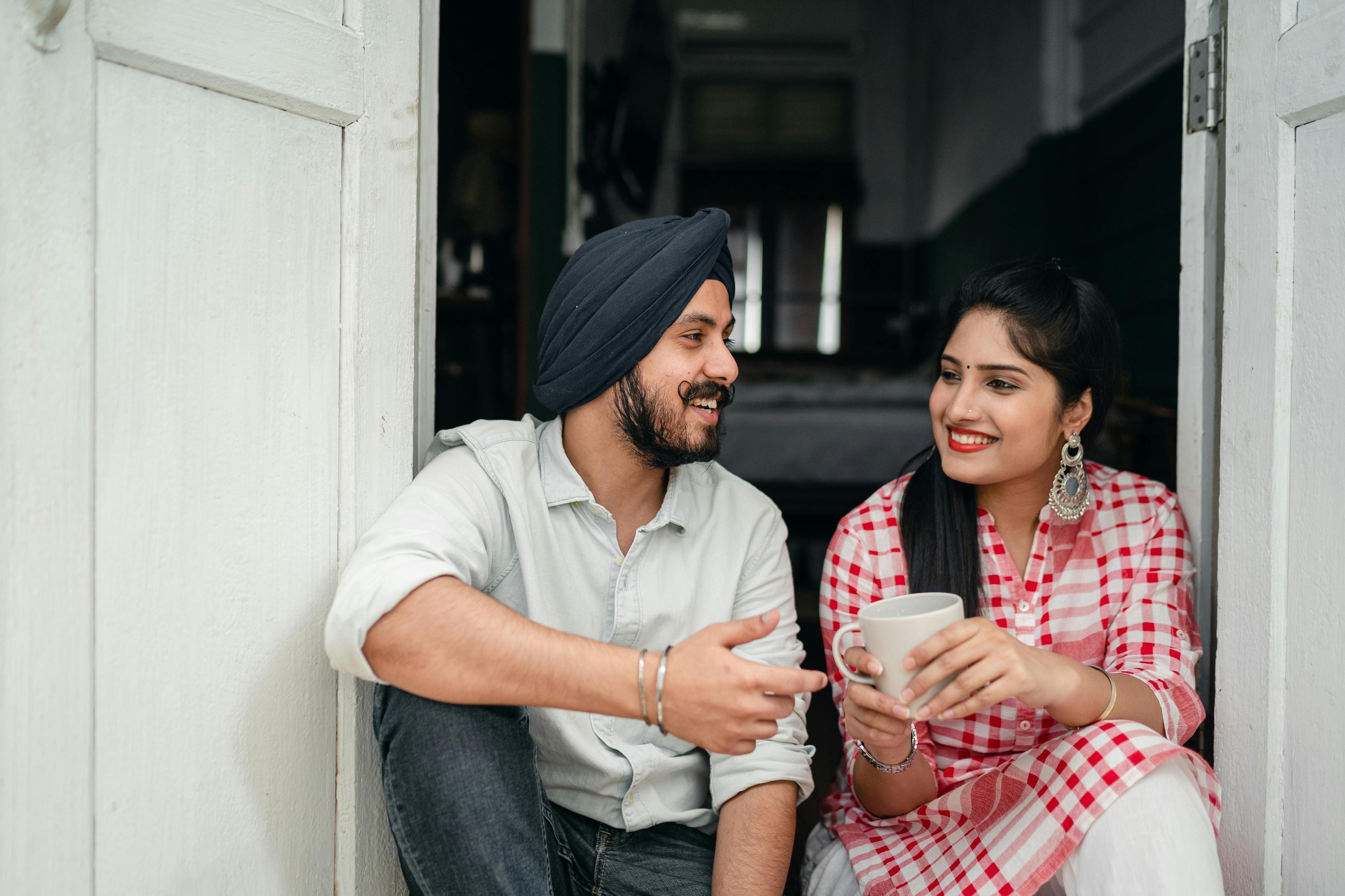 A couple sitting on a bench, facing each other, engaged in deep conversation and practice active listening in their relationship.