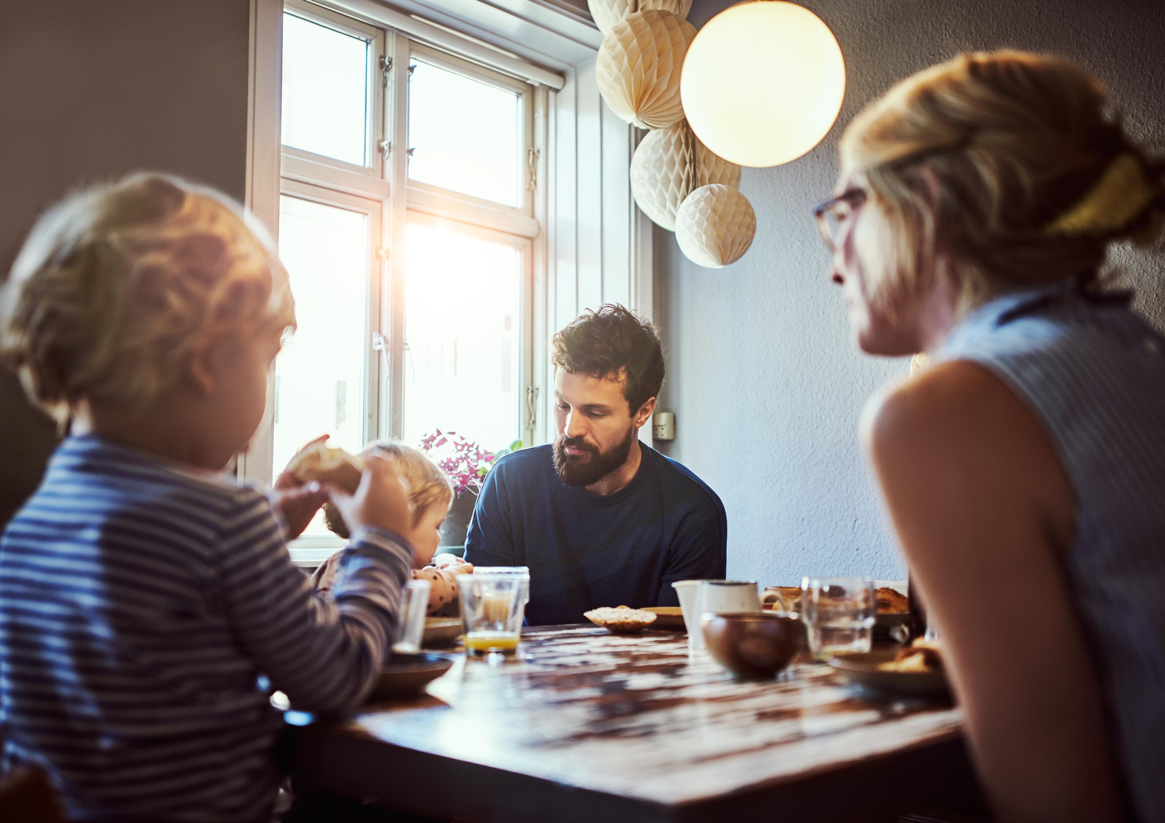 A couple and two children sitting by a table,  portraying a sense of feeling lonely in relationship.