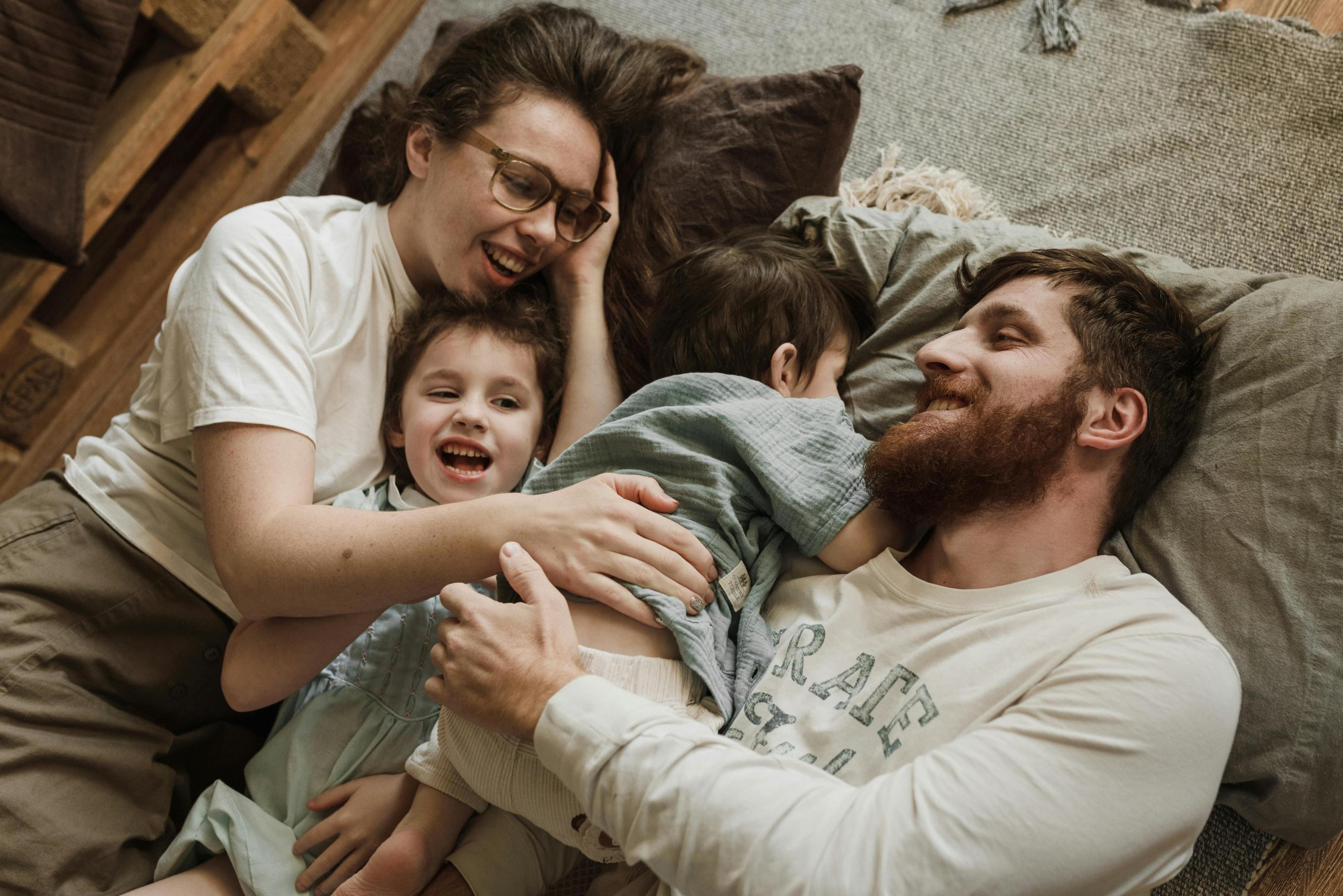 A couple playing with their children after they parctising relationship exercises from couples therapy.