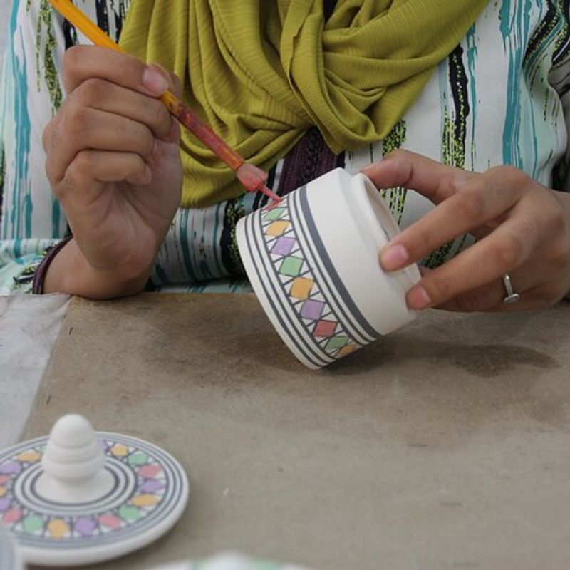 Artisan hand-painting a ceramic tile