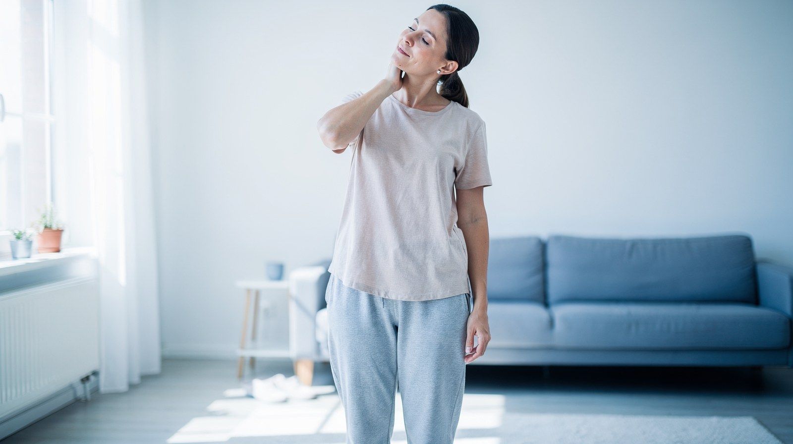 Una donna esegue lenti esercizi di mobilità del collo in casa.