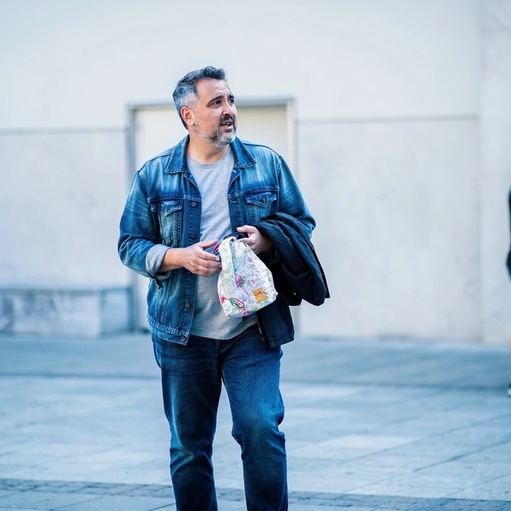 Un uomo si ferma sul marciapiede e si guarda intorno.