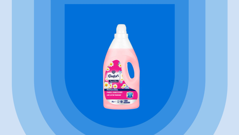 a pink bottle of comfort fabric softener on a blue background