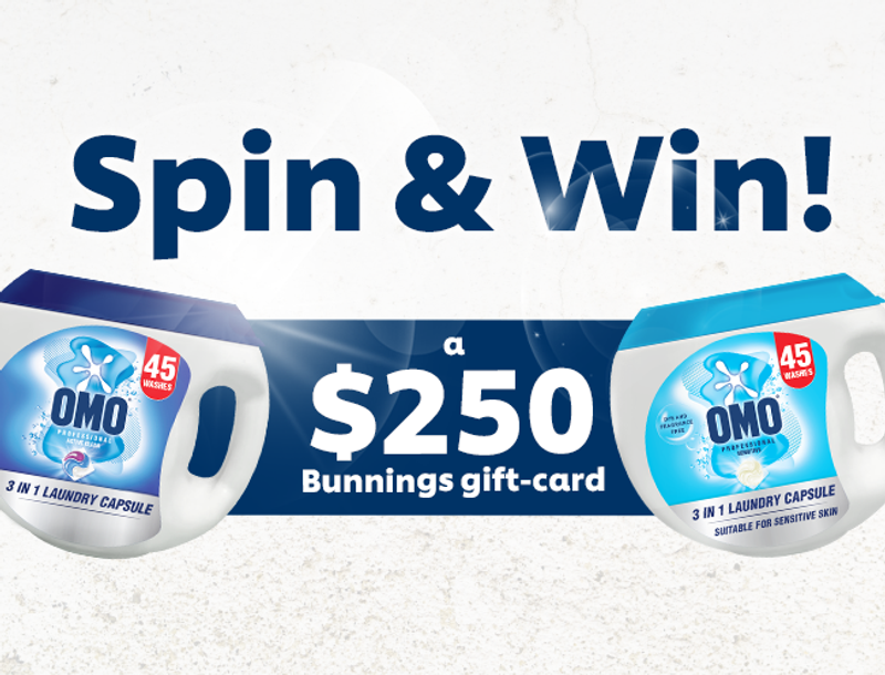 Advertisement for an OMO 'Spin & Win' contest featuring two OMO laundry capsule containers and promoting a $250 Bunnings gift card prize.