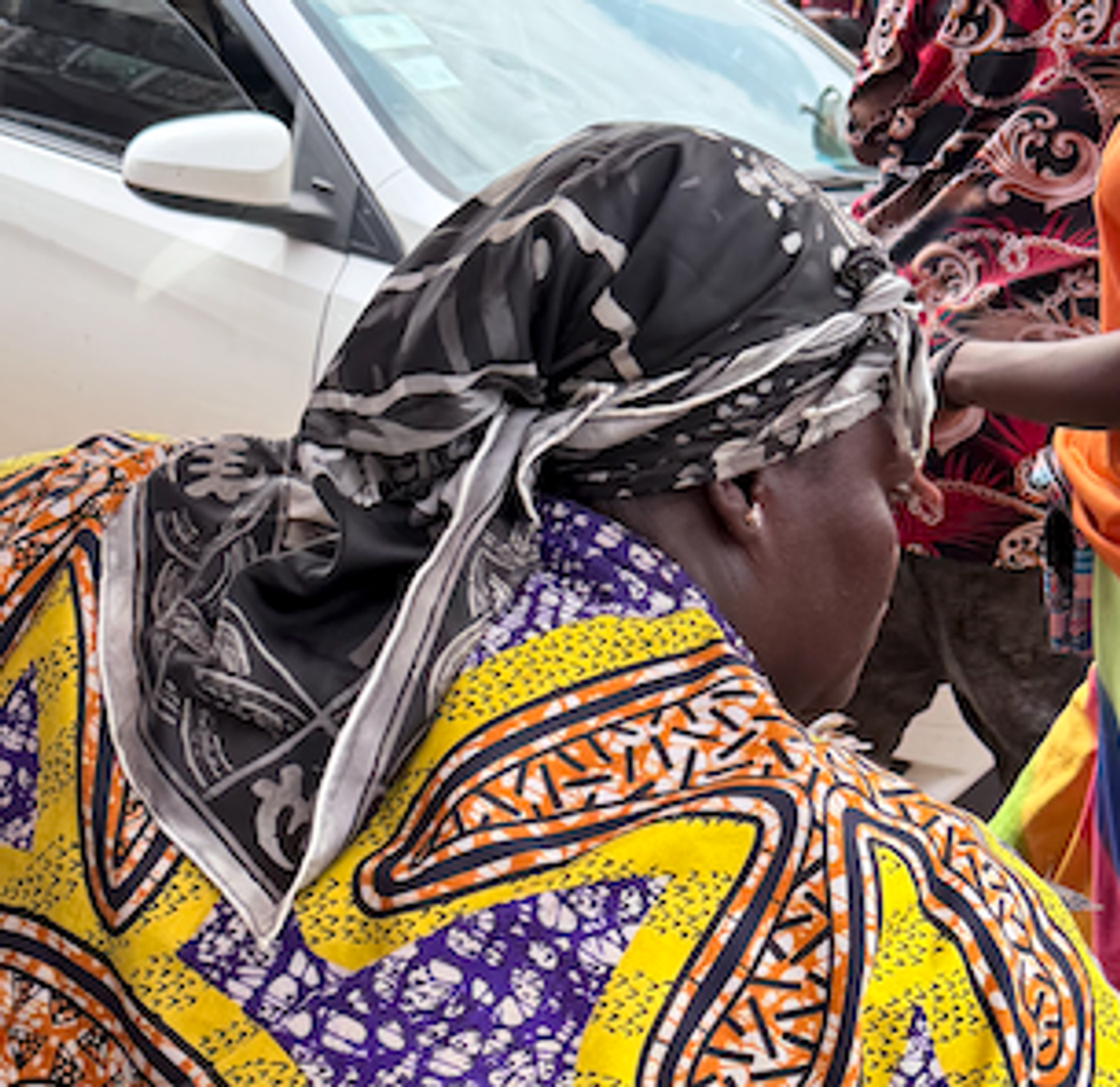 Woman wearing a traditional Ghanaian duku demonstrating structured head wrapping.