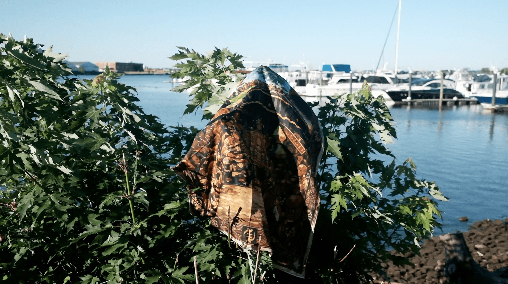 BATA textile draped among coastal foliage beside a marina