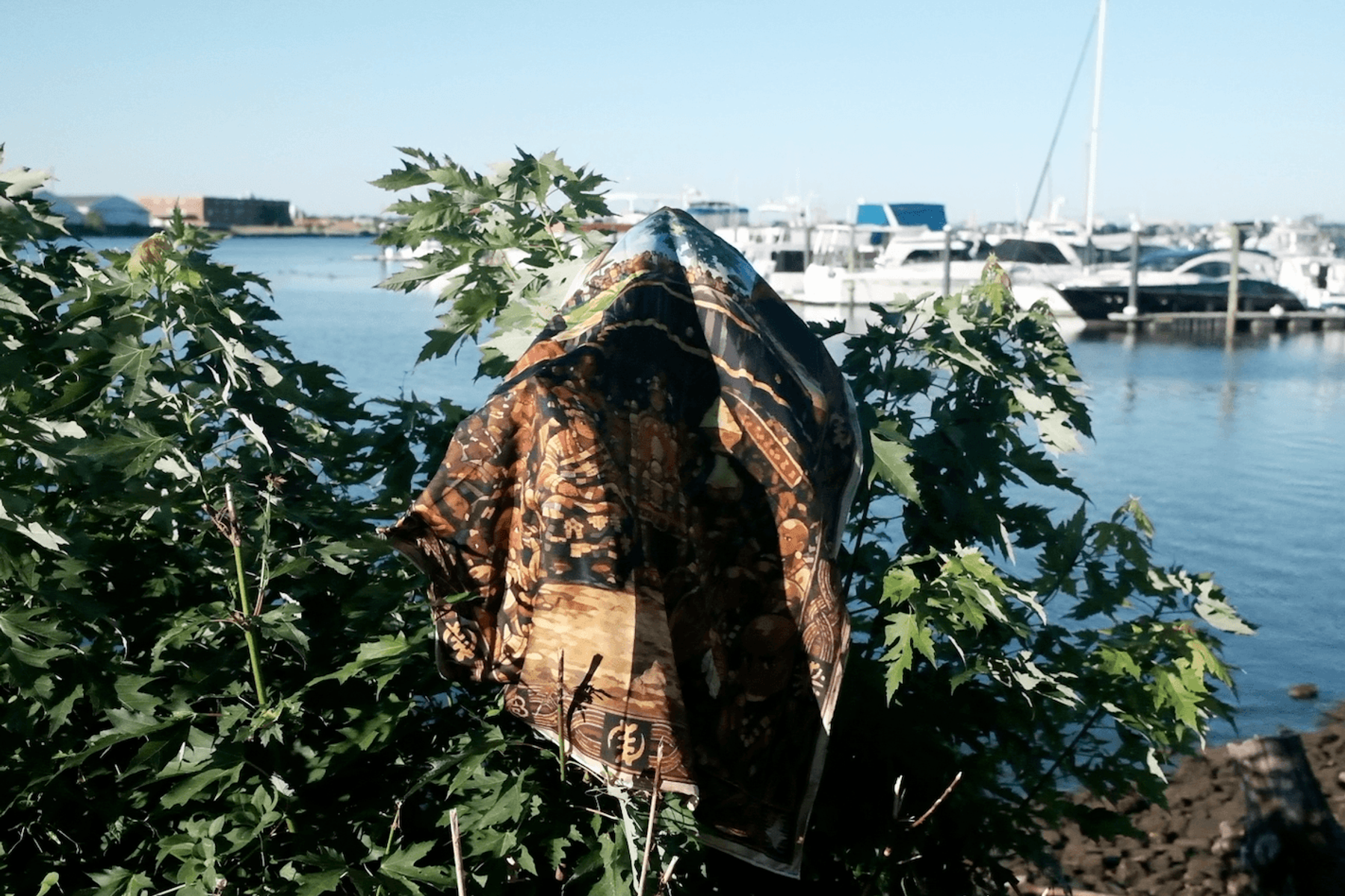 BATA textile draped among coastal foliage beside a marina