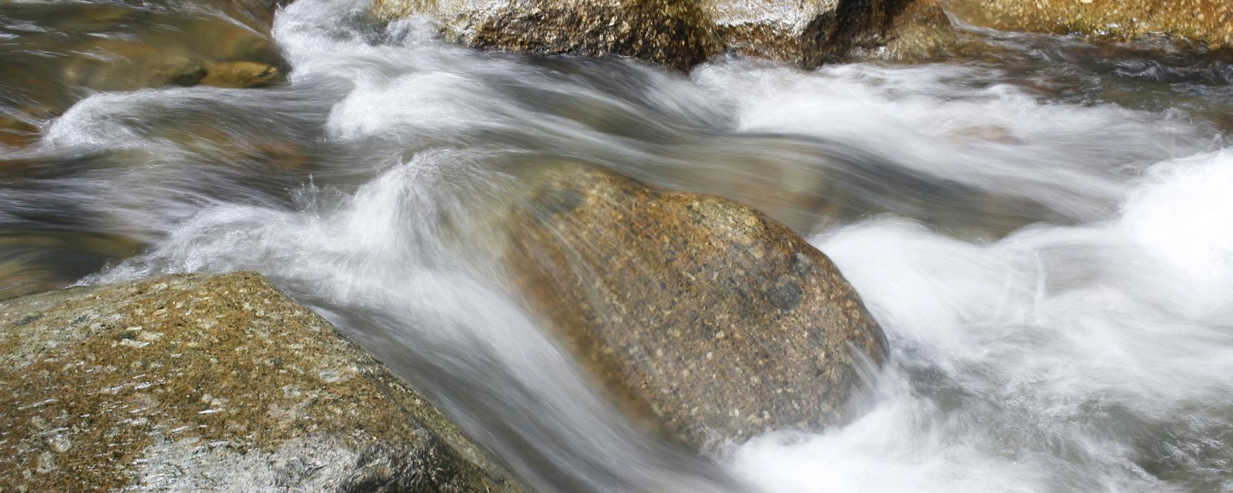 water beweegt tussen stenen (Nasrul Azmee on Unsplash)
