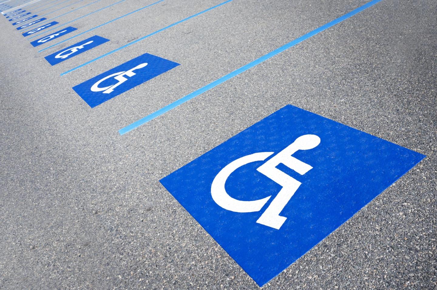 Freshly striped ADA-compliant parking space with proper signage in a commercial lot