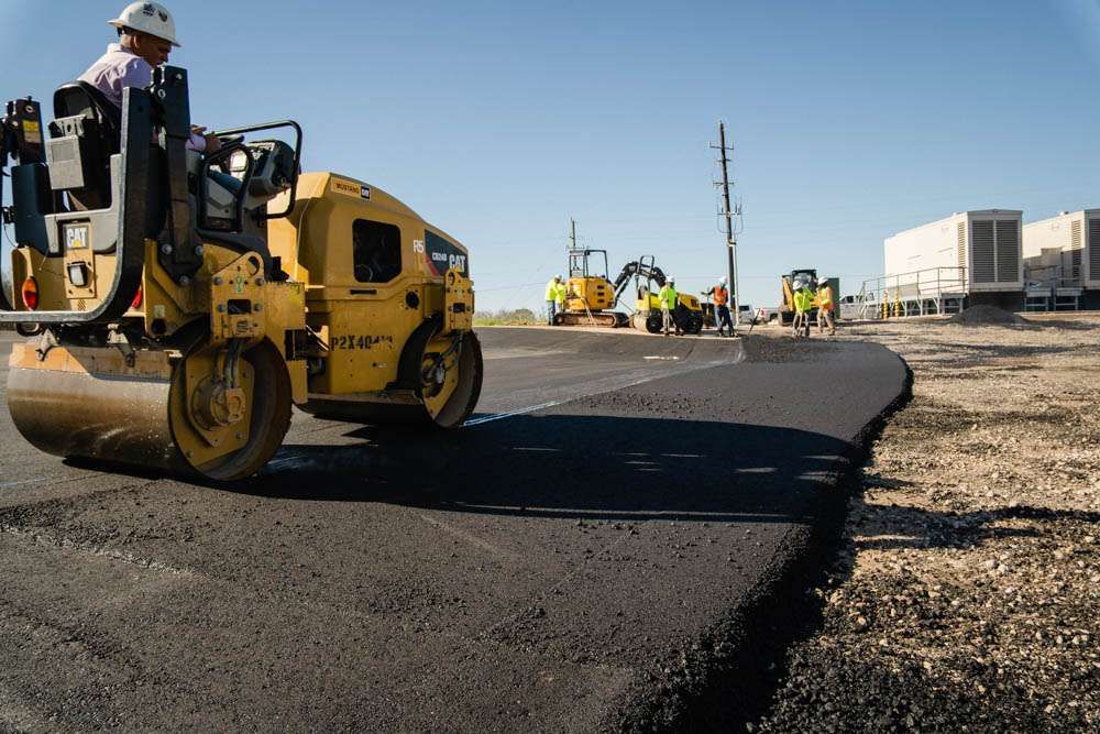 AAA Paving CAT roller compacting fresh commercial asphalt at a Houston industrial site