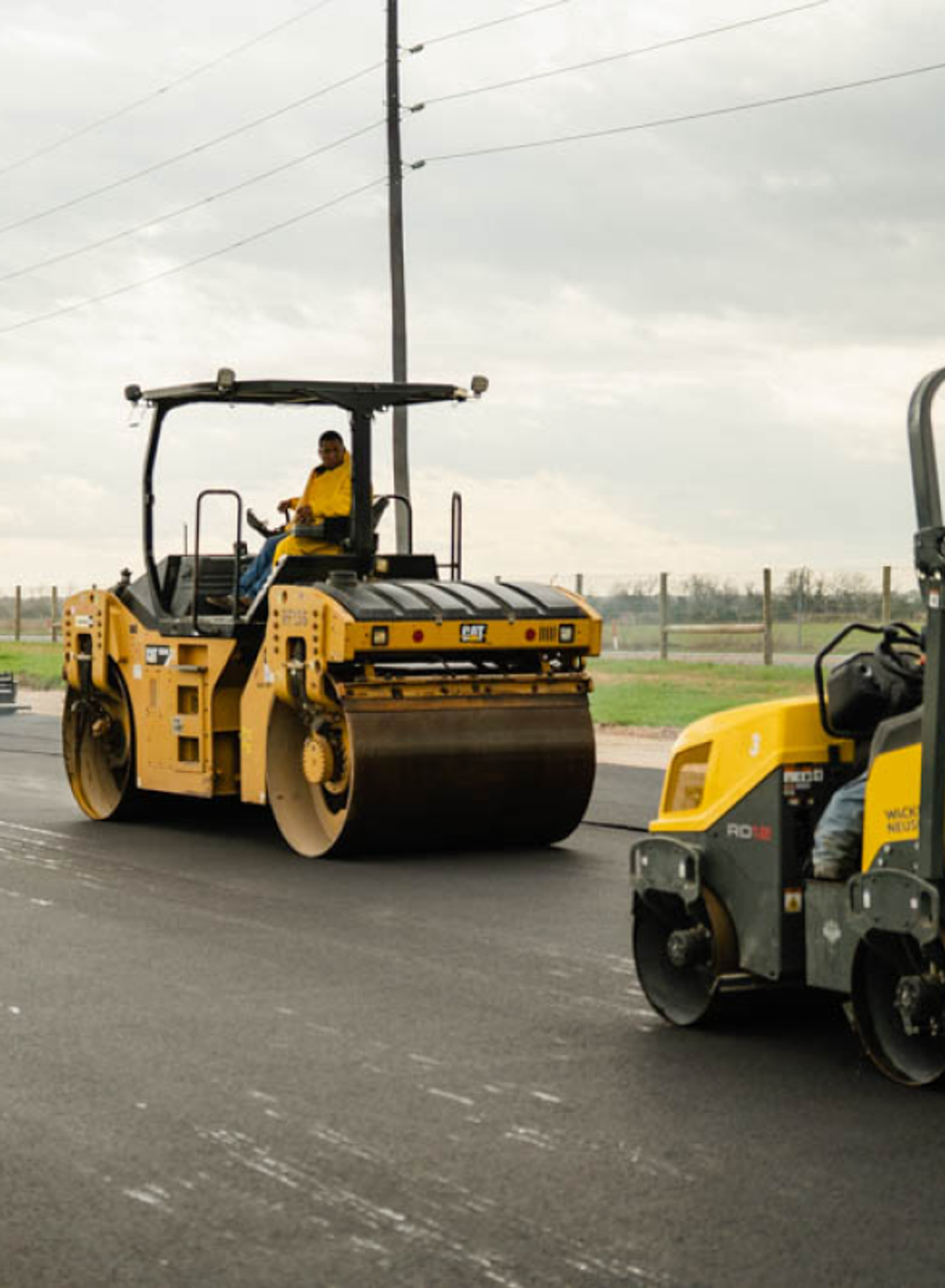 Two AAA Paving rollers compacting a fresh asphalt mat on a commercial site