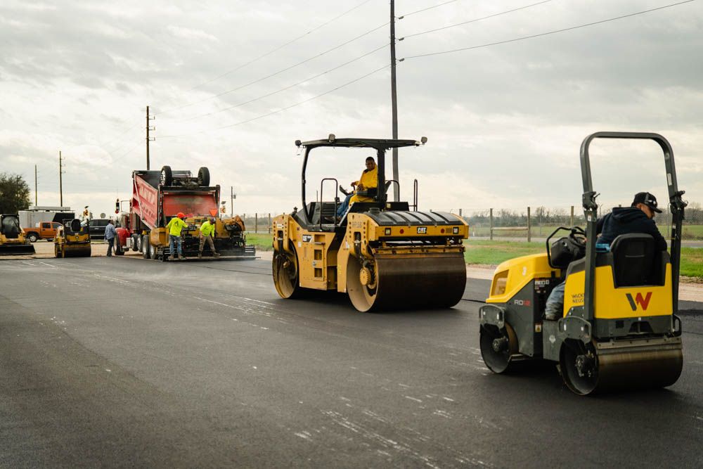 AAA Paving crew and roller compacting fresh asphalt on a Houston commercial job site