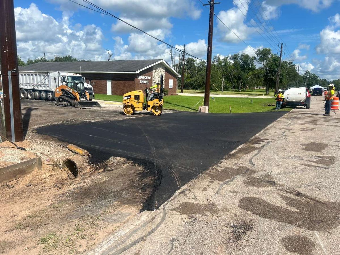 AAA Paving roller compacting a fresh asphalt parking lot at a Texas church