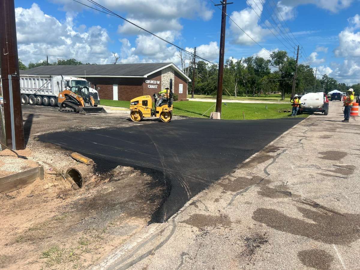AAA Paving roller compacting a fresh asphalt parking lot at a Texas church