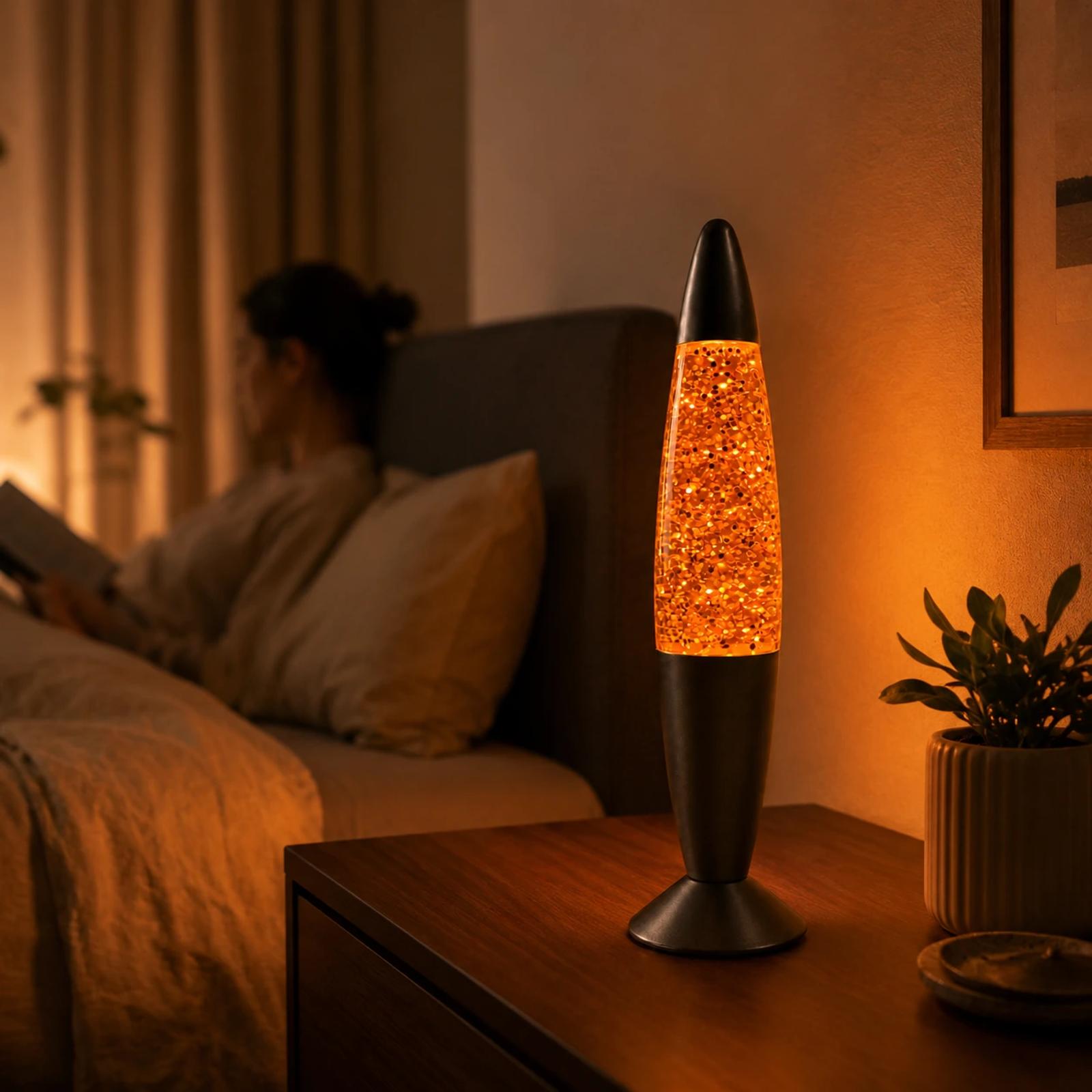 MX-3013 warm orange glass glitter night light glowing on a bedside table in a cozy bedroom scene with soft background human context.