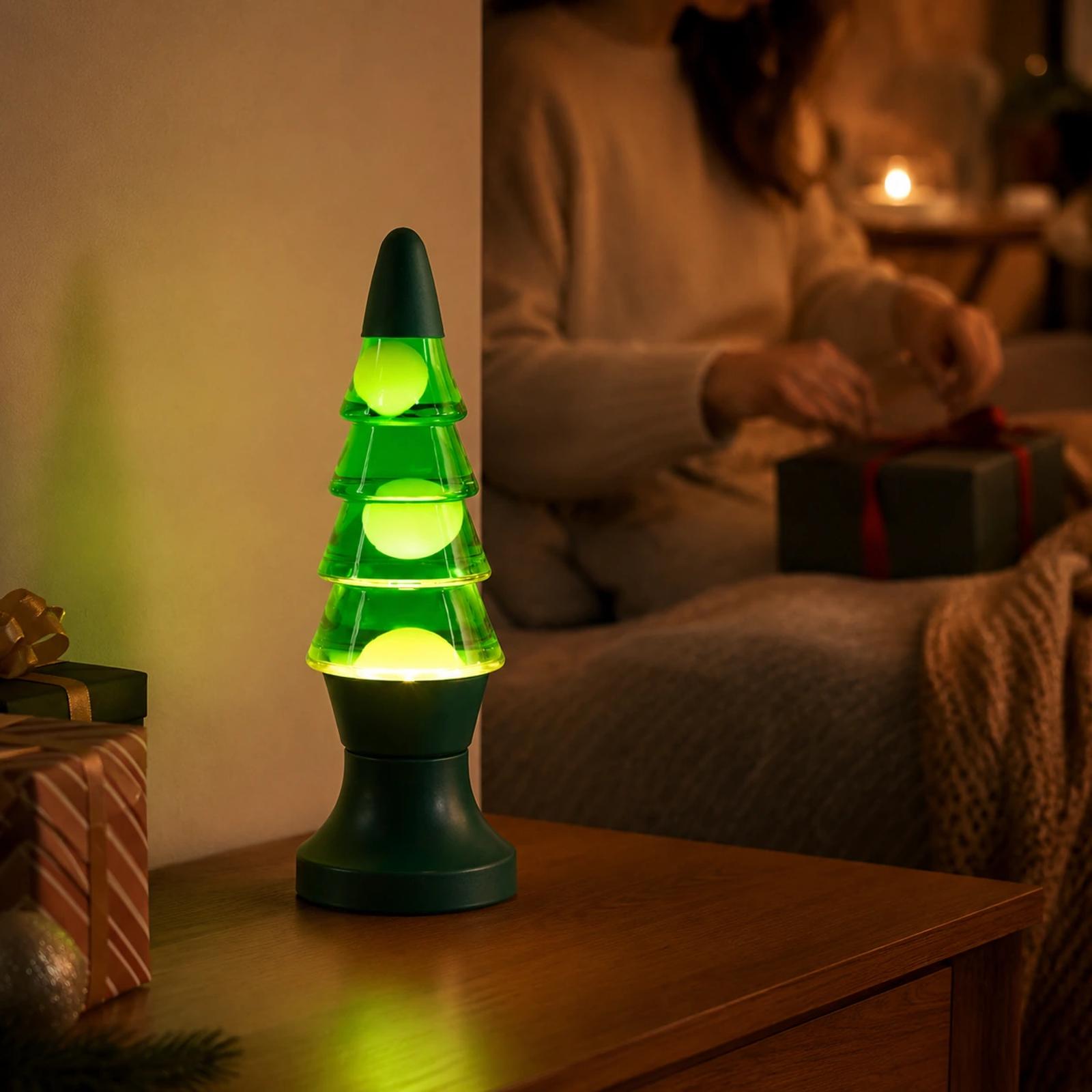 MX-3020 Christmas tree lava lamp glowing on a bedside table in a cozy holiday room with soft background context.
