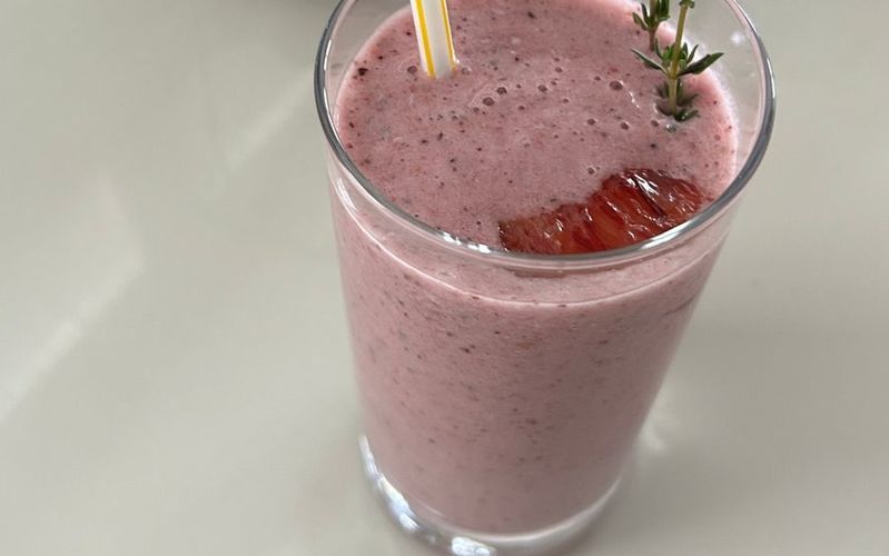 A berry smoothie garnished with thyme