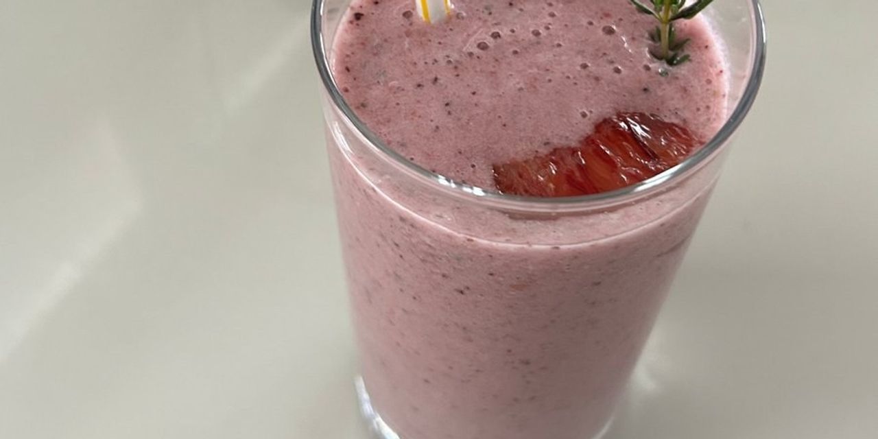 A berry smoothie garnished with thyme