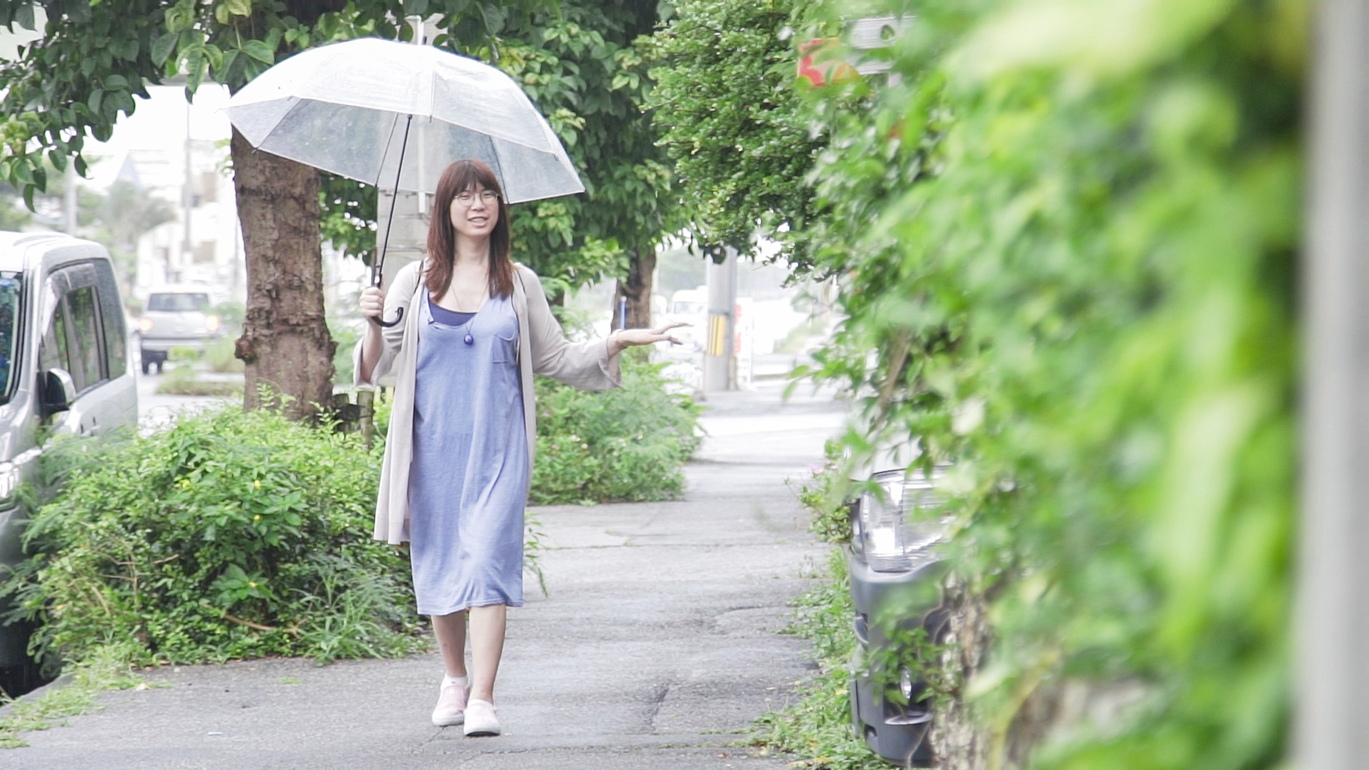 A woman walking down a street while holding an umbrella.
