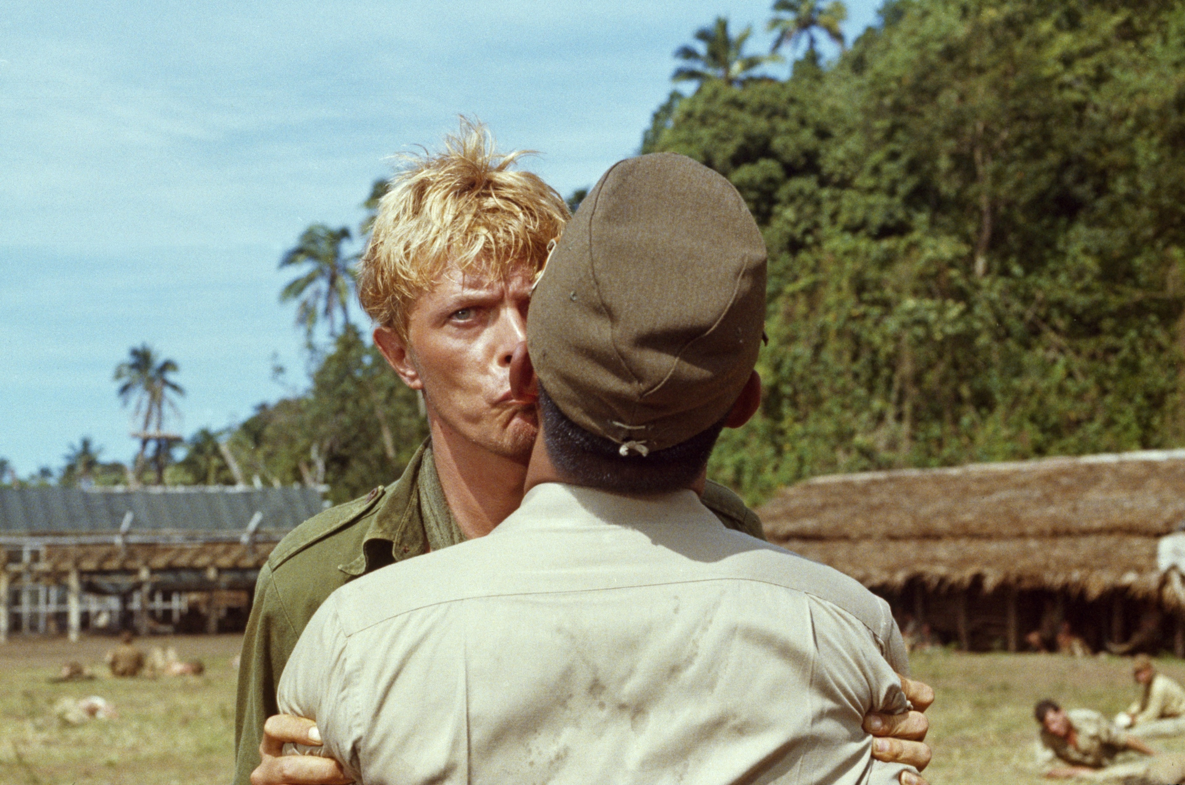 David Bowie kissing a man.