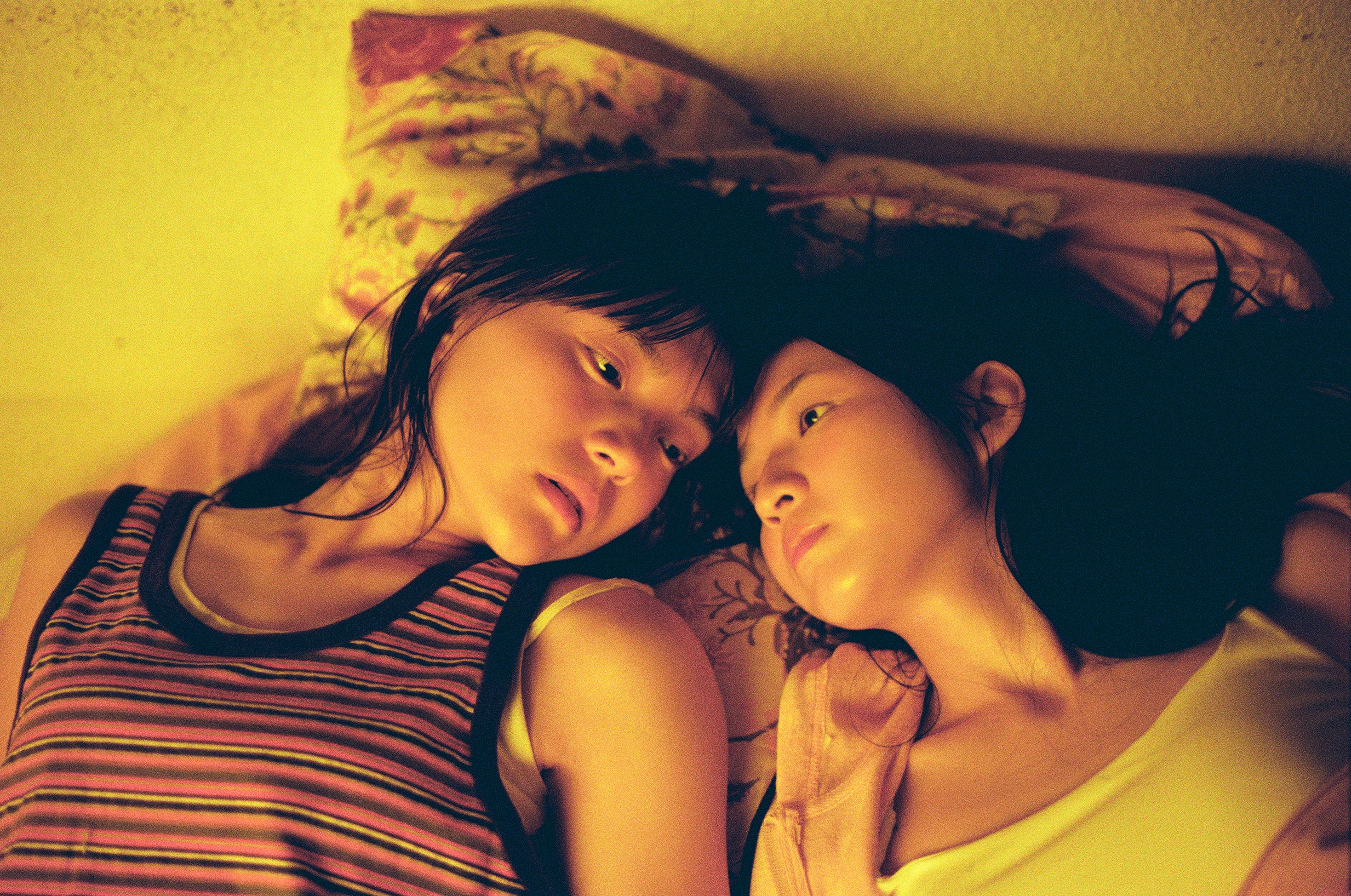 Two girls lie side by side/