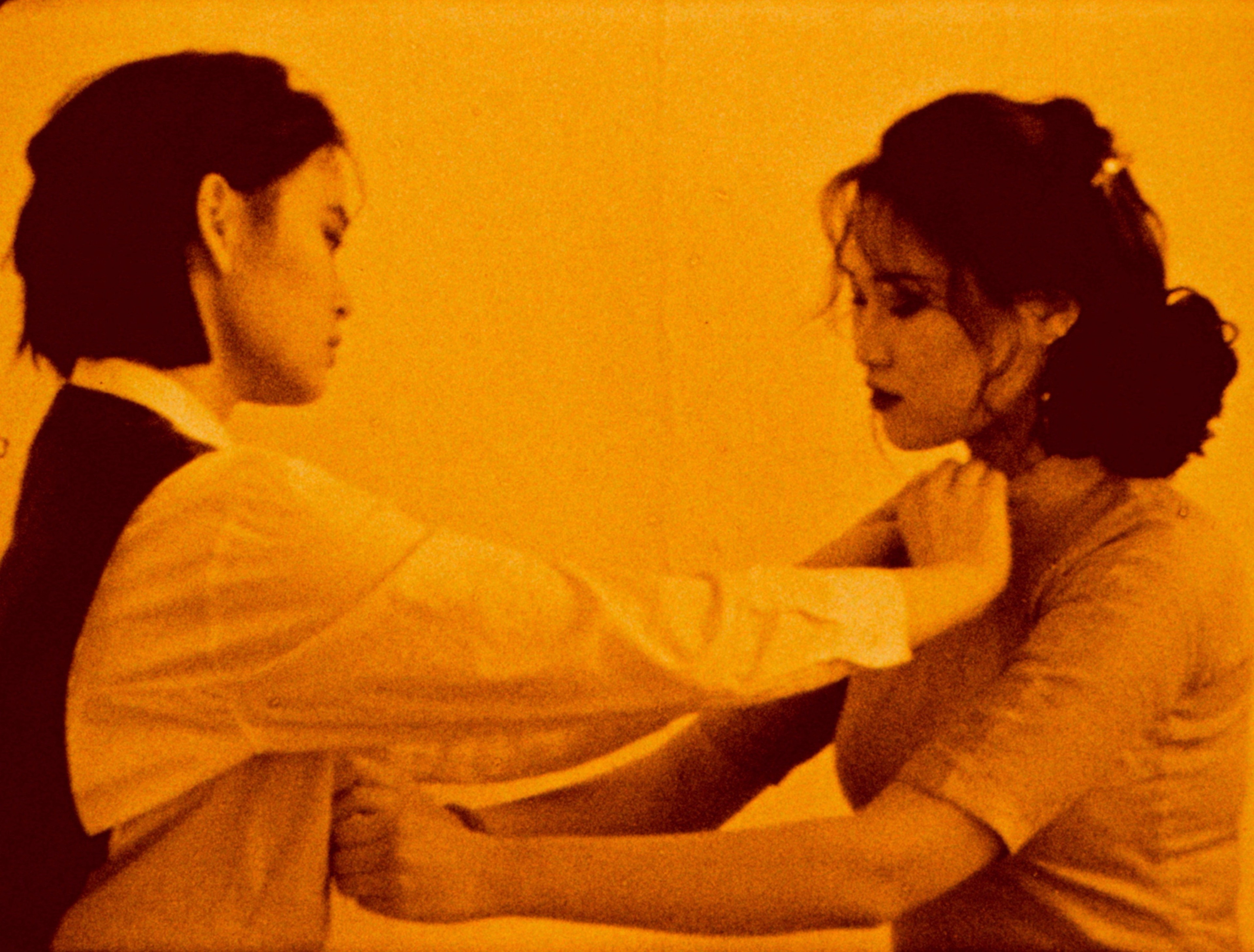 Two figures do each other's buttons up.